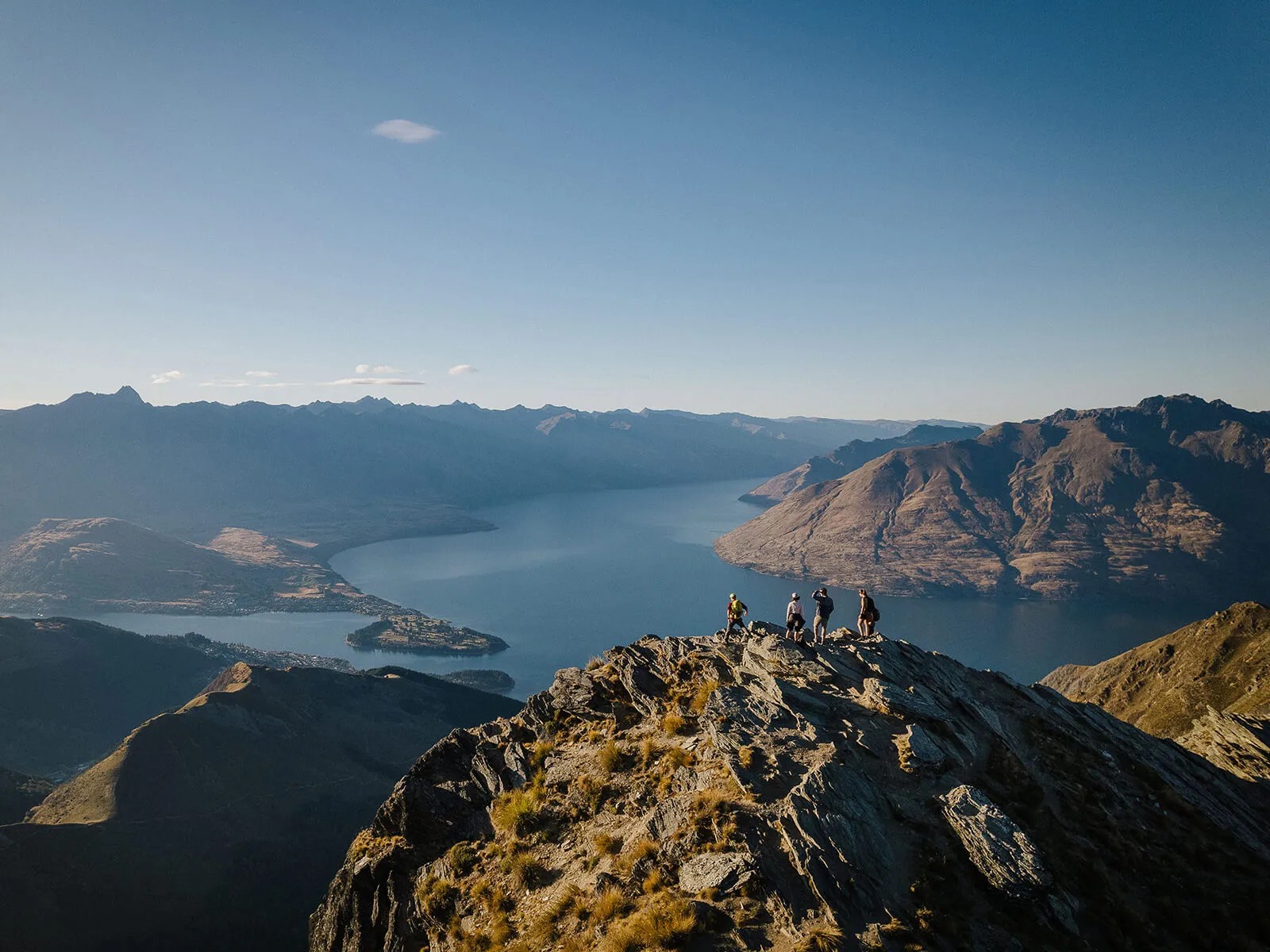 Aerial view of a group of people looking at the sights of the Wakatipu basin from the Ben Lomond summit.