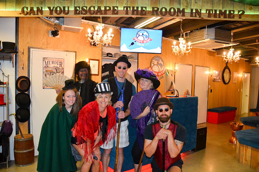 A group of friends are dressed up in bright costumes at the Escape Room Queenstown.