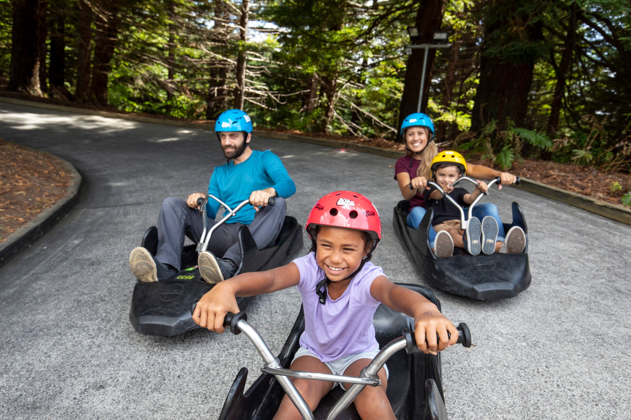Family with children enjoying the Skyline Rotorua Luge.