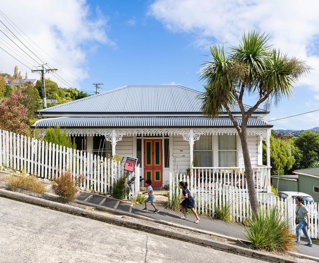 A family walks up Baldwin street, the worlds steepest street located in Dunedin.