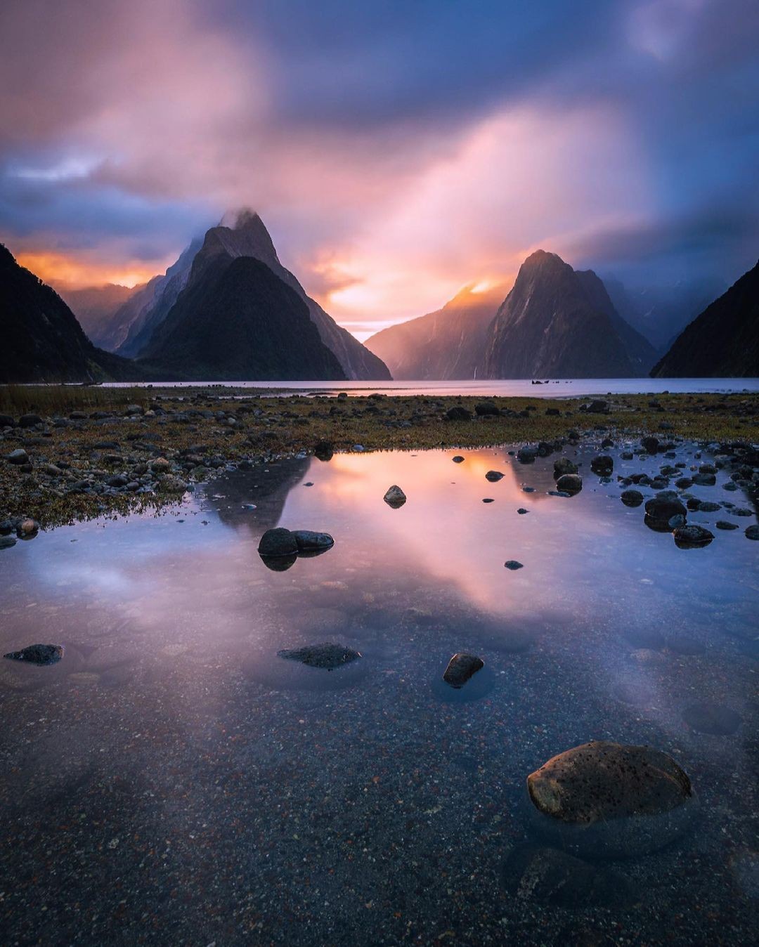 A stunning sunset illuminating the towering peaks of Milford Sound.
