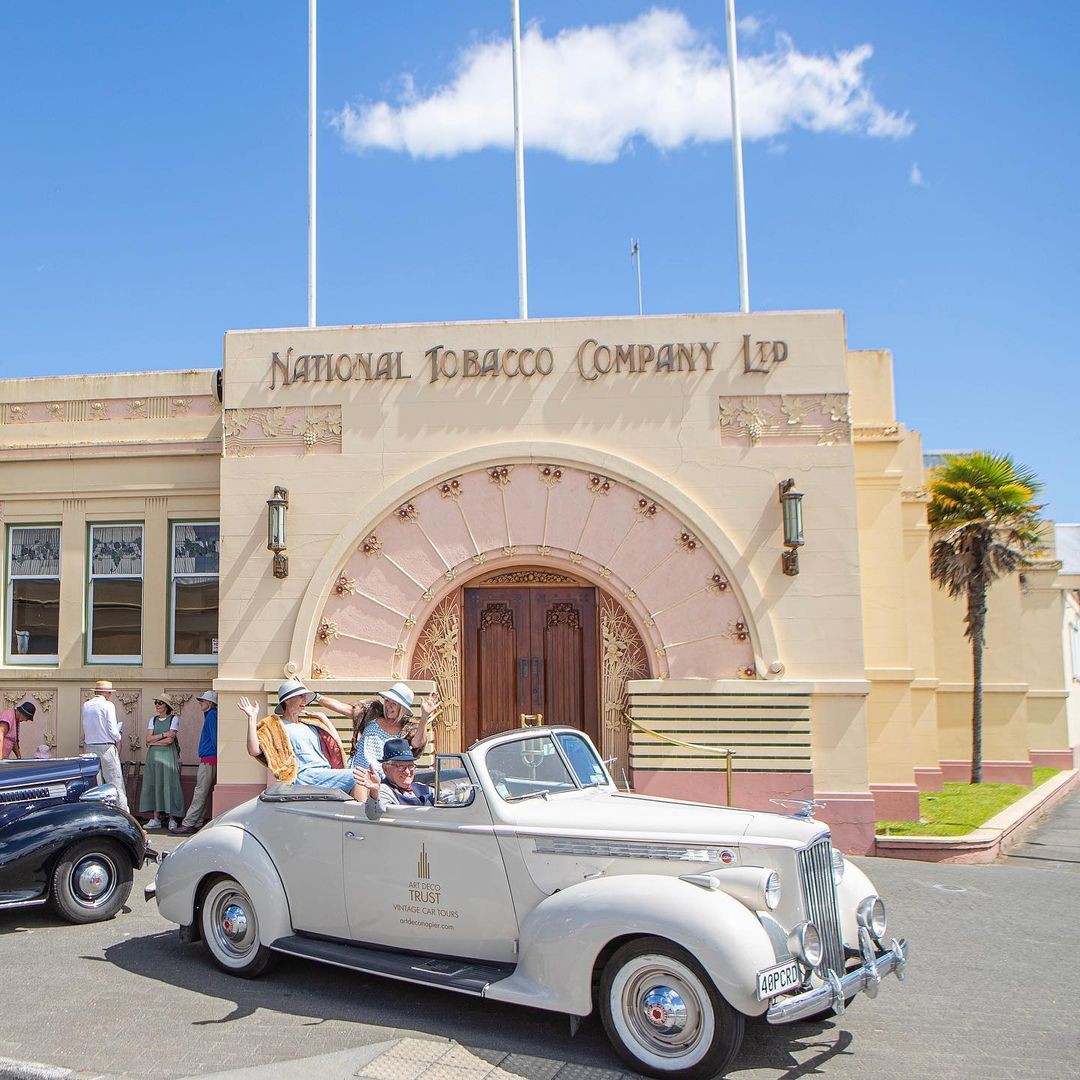 A vintage car parked in front of the art deco 'National Tobacco Company Ltd' building in Napier, Hawkes Bay.