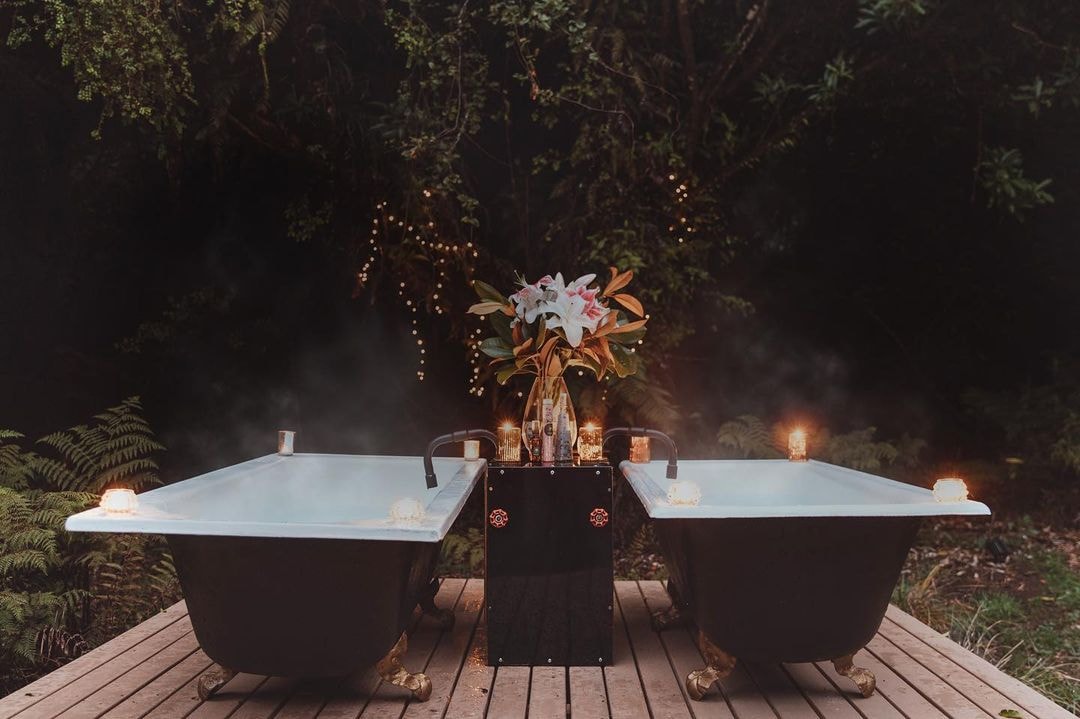 Two outdoor bathtubs positioned on a wooden deck at Twisted Twig Glamping - Rotorua.