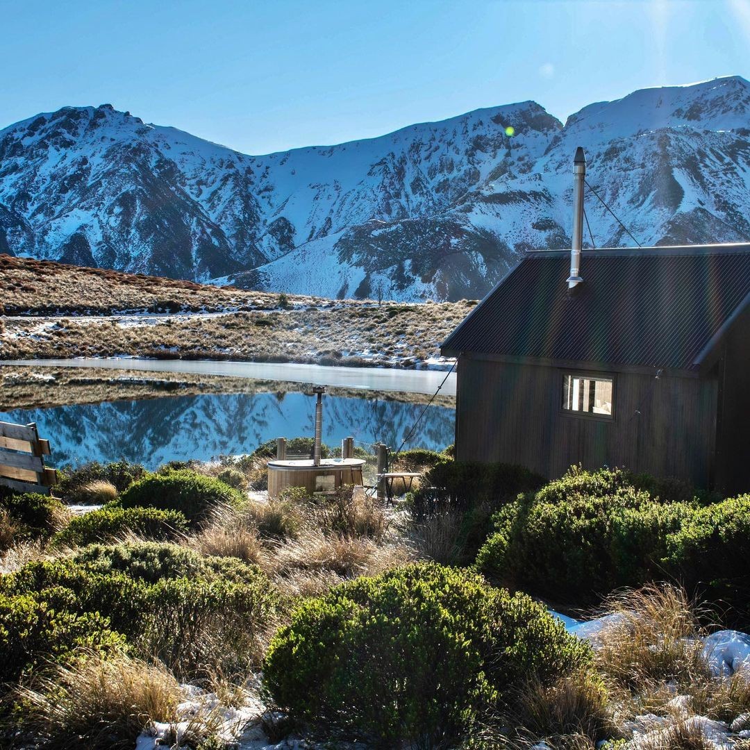 Lake Stella Mountain Hut in the morning light with the hot tub next to Lake Stella.