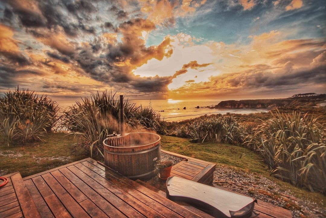 A steaming hot tub positioned in front of the magical view from Woodpecker Hut.