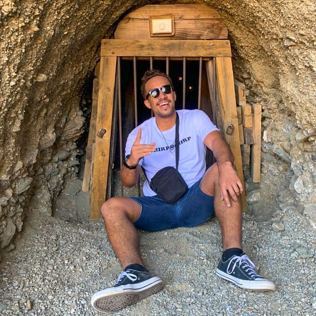 A man poses for a photo in front of an old gold mining tunnel at the Goldfields Mining Centre in the Cromwell Gorge.