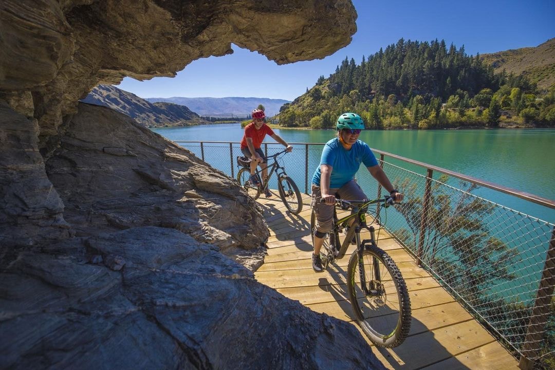 Some friends ride their bikes around a corner on the lake Dunstan trail between Cromwell and Clyde.