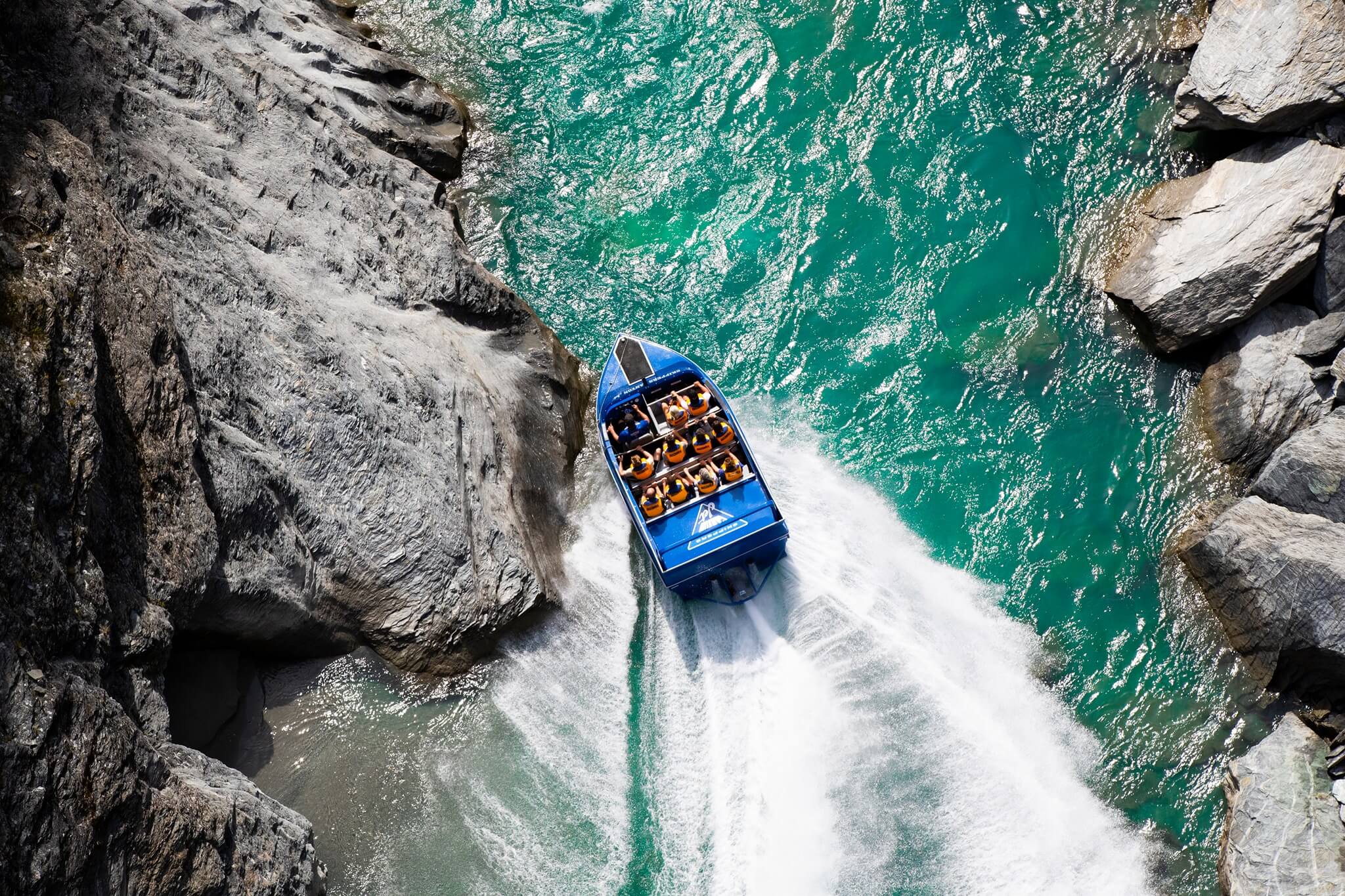 The Skippers Canyon Jet boosts past a rocky outcrop on the Shotover River in Queenstown.