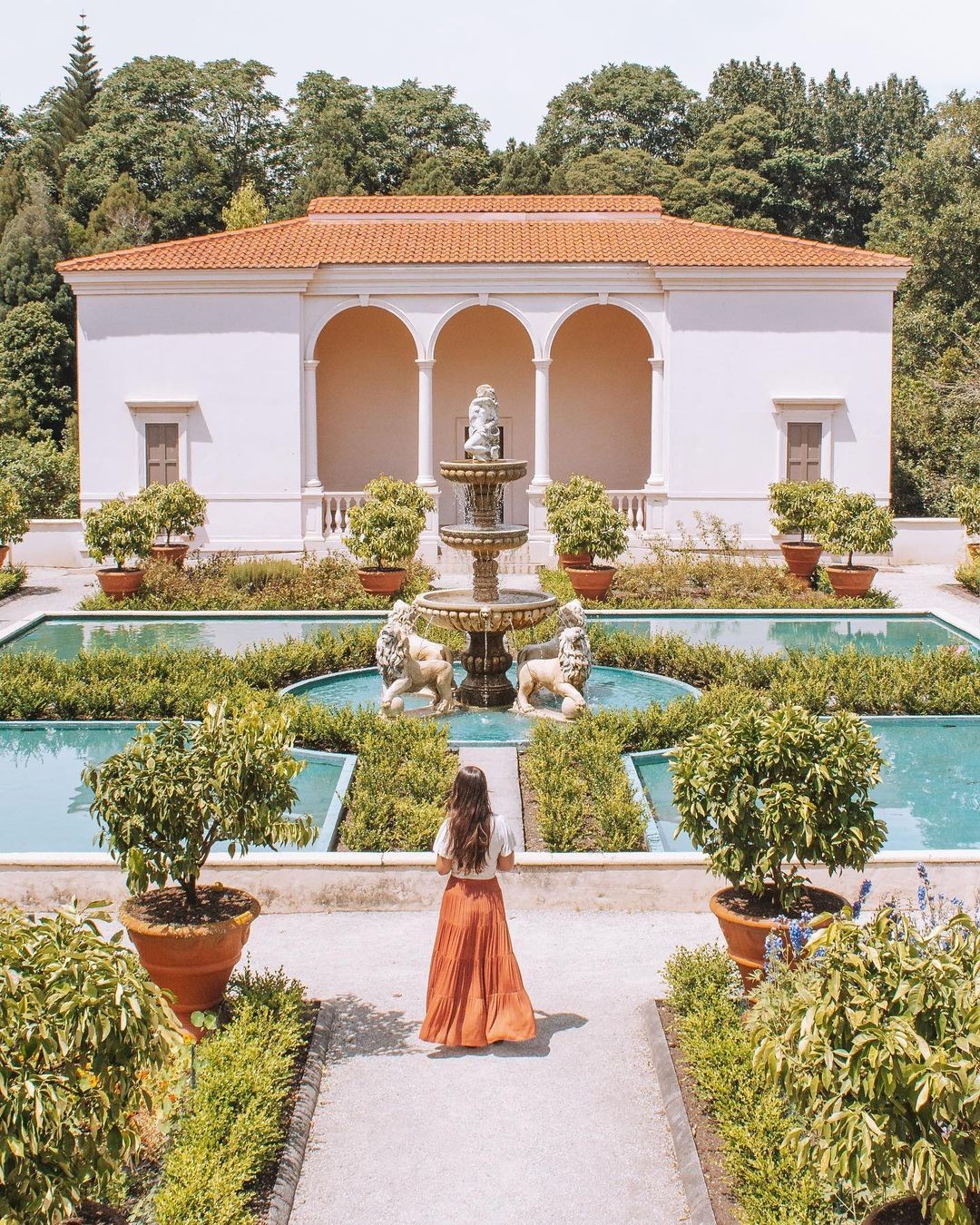 A woman in a long skirt wanders around the Hamilton gardens on a beautiful day.