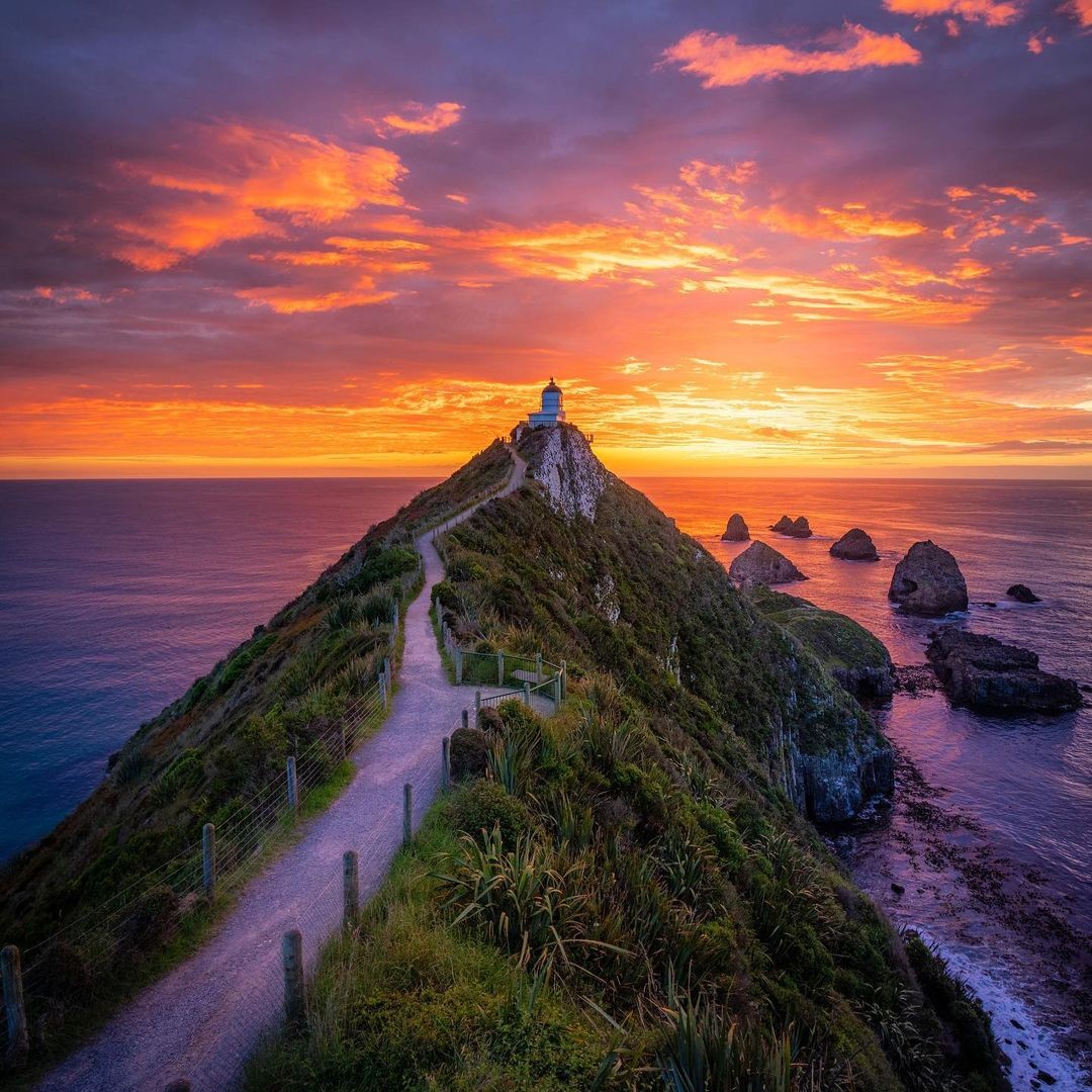 The Nugget Point Lighthouse with a fire red sky at sunset.