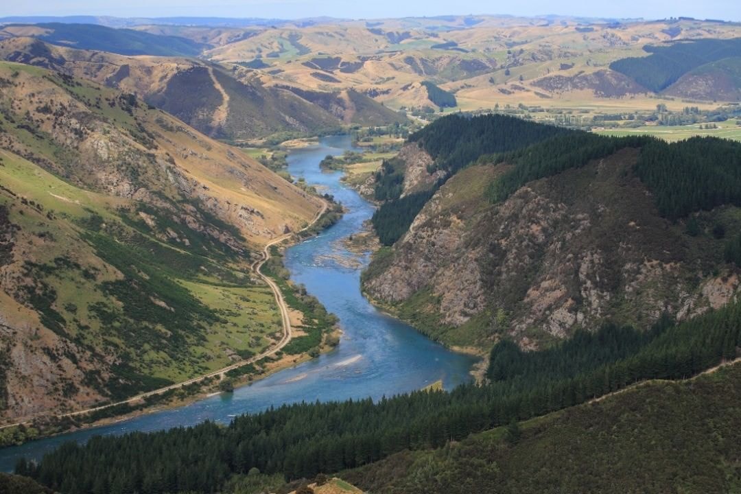 The Clutha river snakes its way through a valley with a cycle trail closely following the banks.