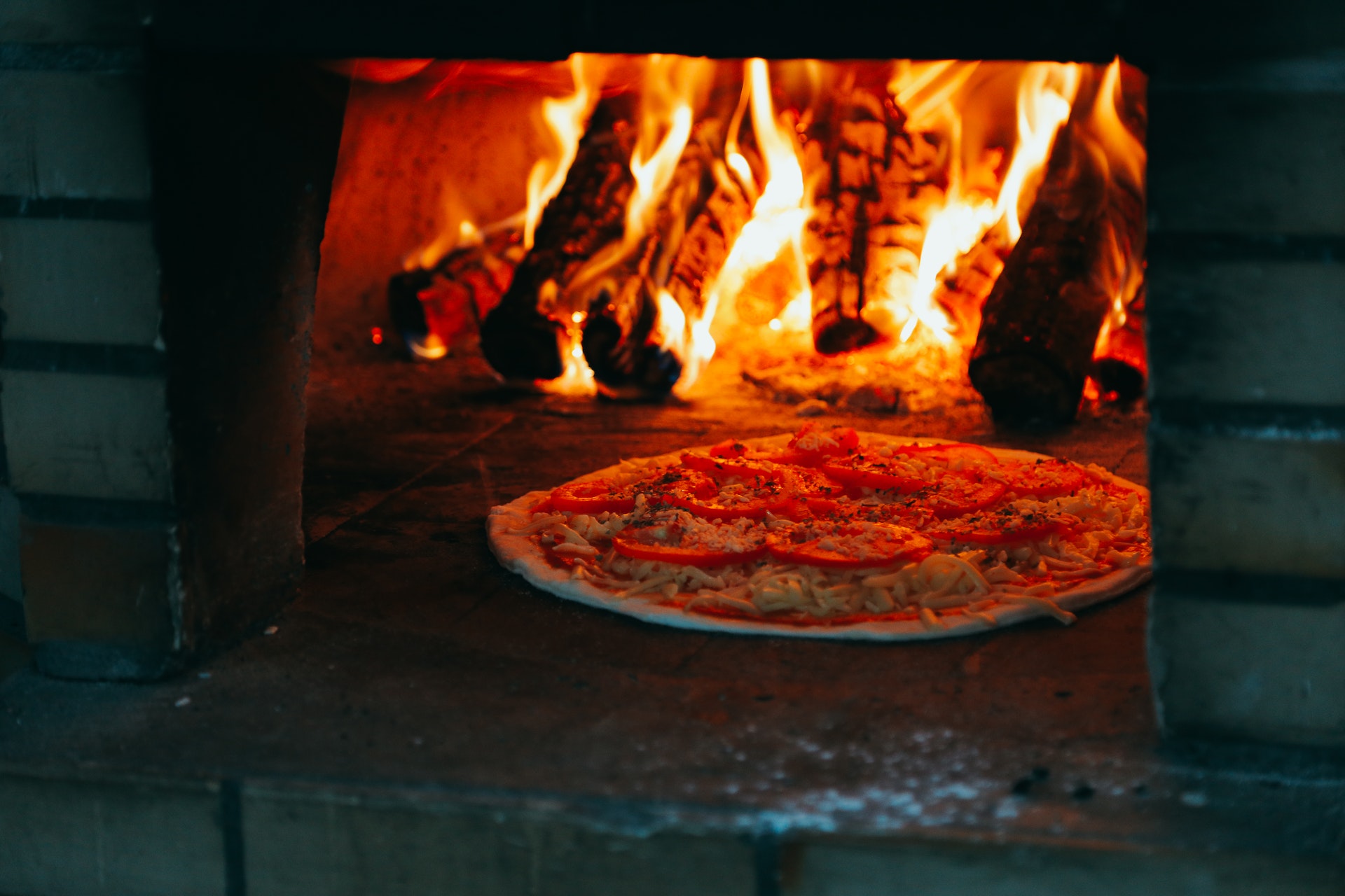 Pizza cooking in a wood fired pizza oven.