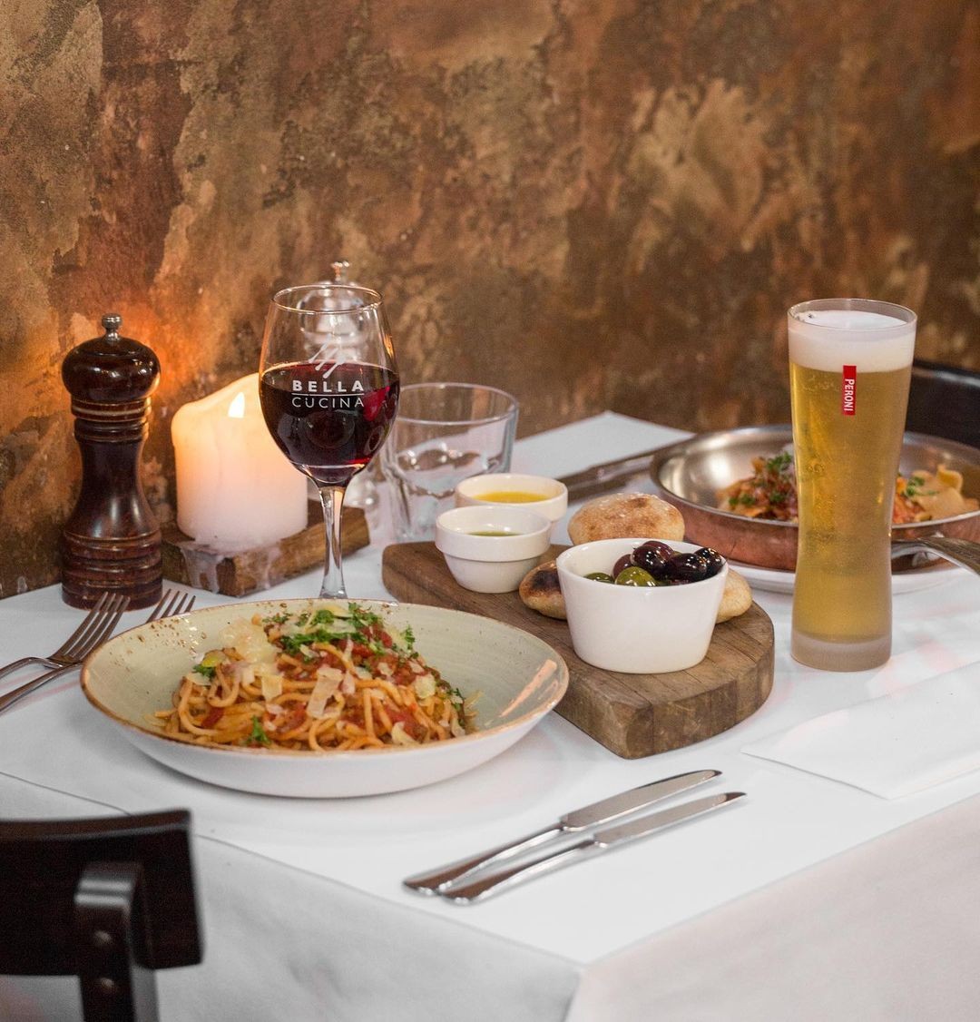 A delicious selection of fresh made pasta dishes with an entrée of olives and bread with olive oil in the middle at Bella Cucina Queenstown.