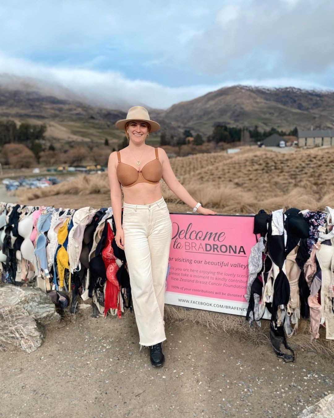 A woman poses in front of the Bradrona fence in the Cardrona Valley near Wanaka.