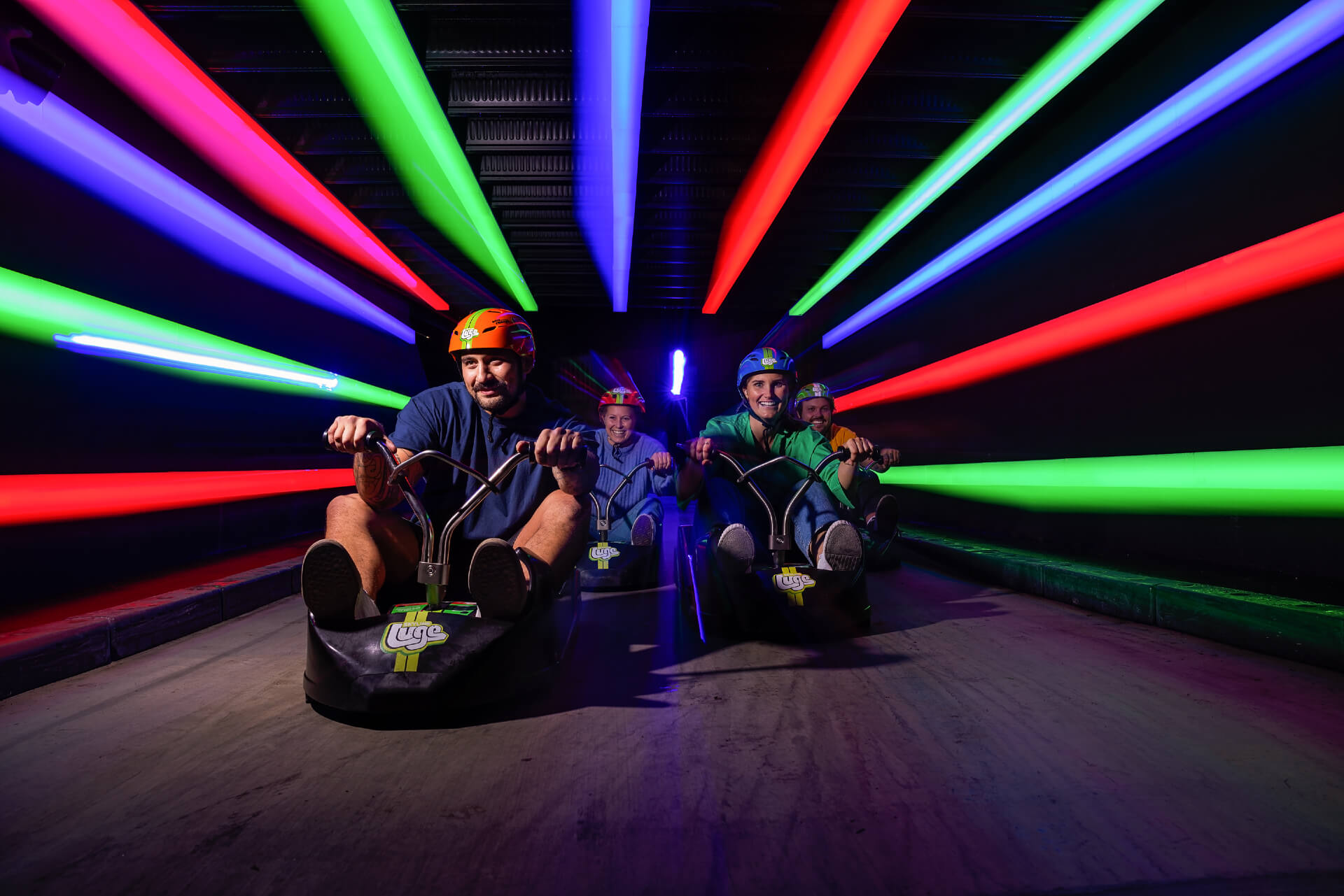 Friends head through an illuminated tunnel on the Rotorua Night Luge.