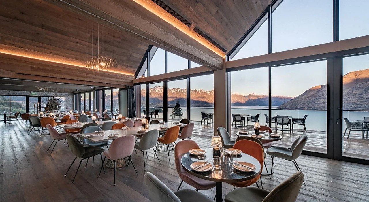 A coffee sits on a bed in the Kamana Lakehouse overlooking the lake.