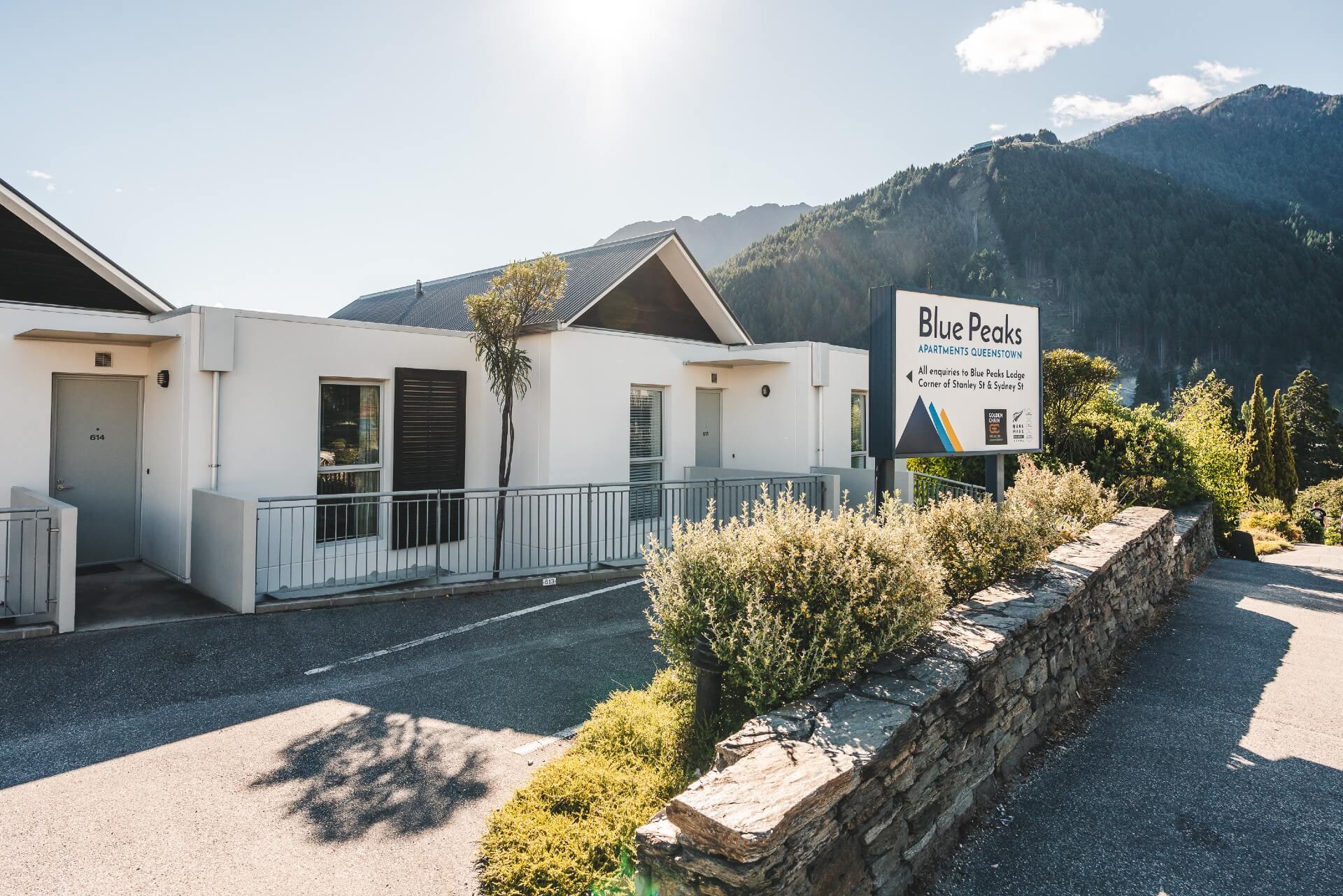 An exterior photo of the Blue Peaks Apartments with the Skyline Queenstown Gondola in the background.