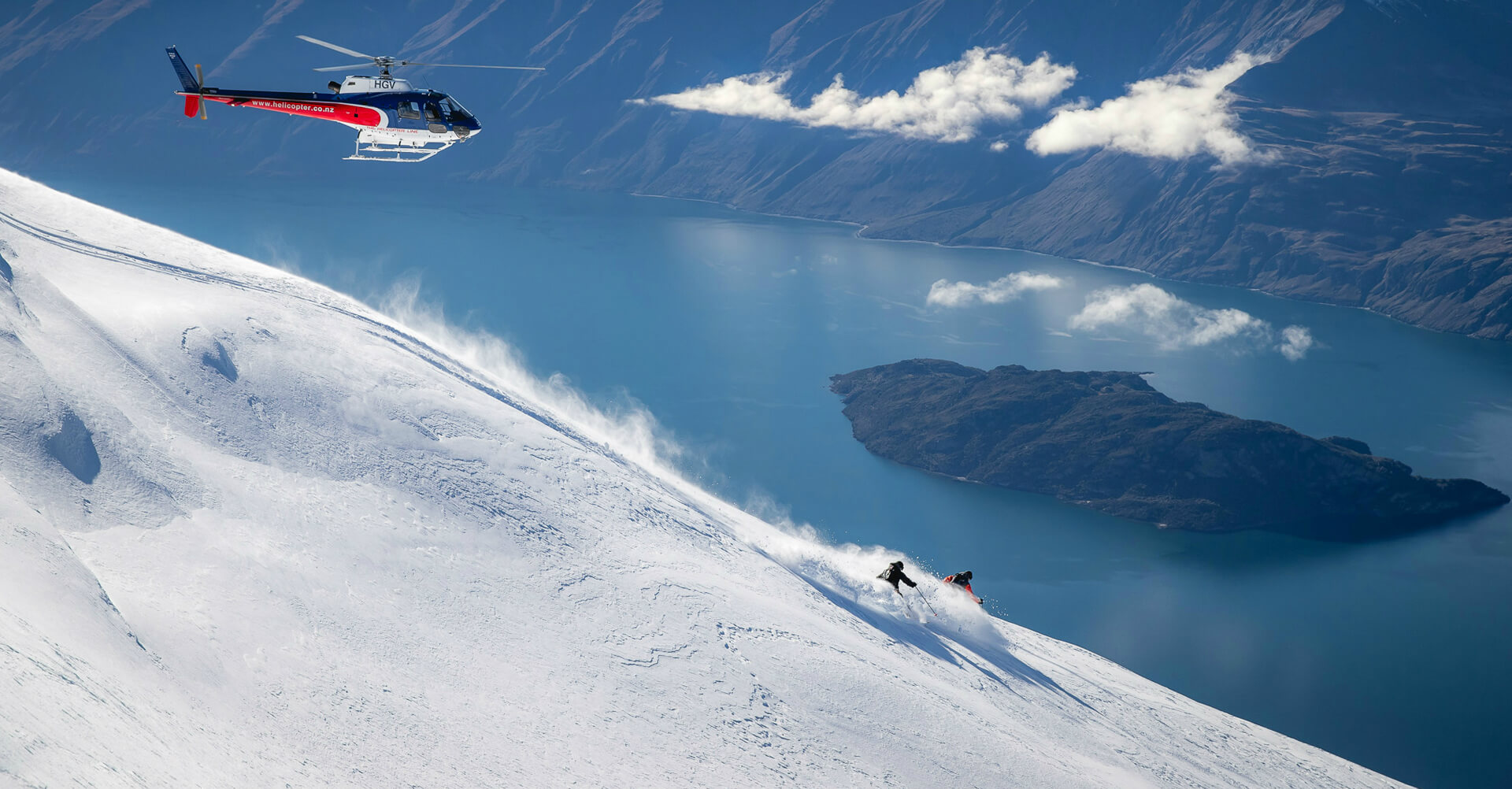 Two skiers shred some fresh powder on the side of Lake Wanaka in New Zealand.