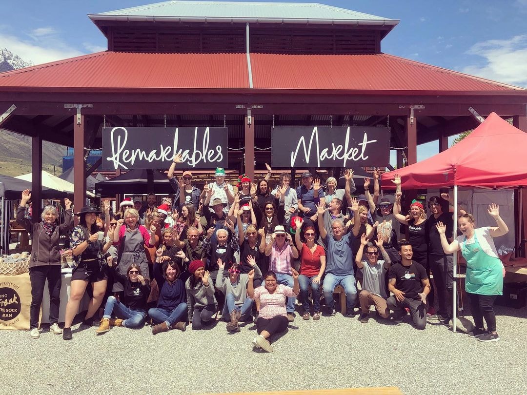 All the stall vendors at the Remarkables Market pose for a photo in front of the main sign.