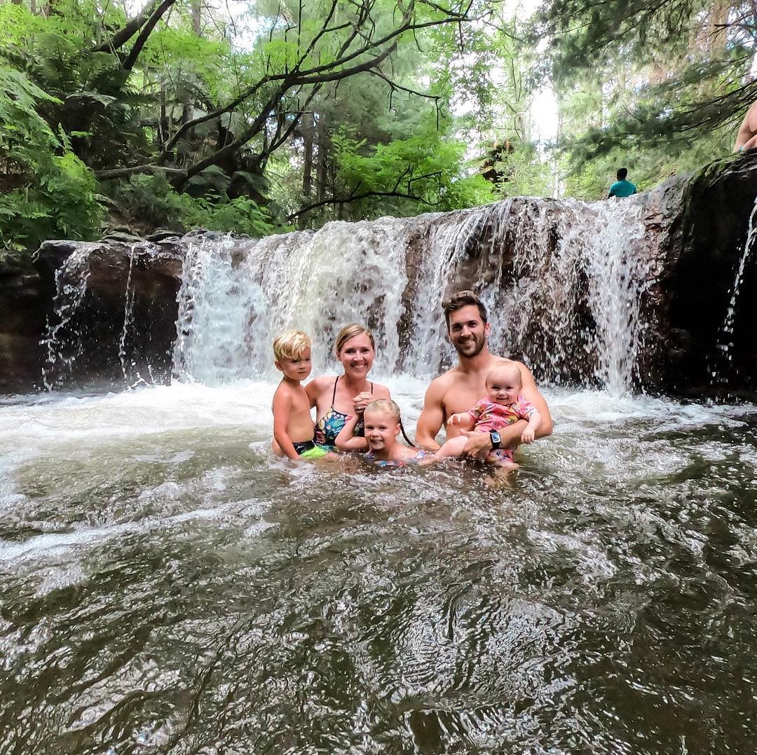 A family of 5 enjoys the naturally heated waters of Kerosene Creek in Rotorua.