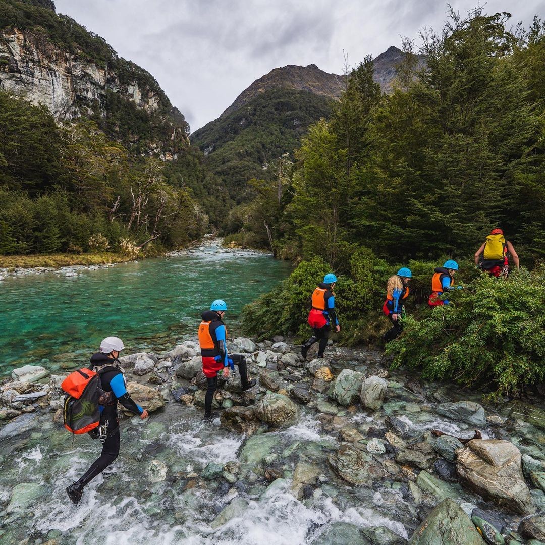 A group of customer follow their guide up stream as they prepare to go canyoning in Queenstown.