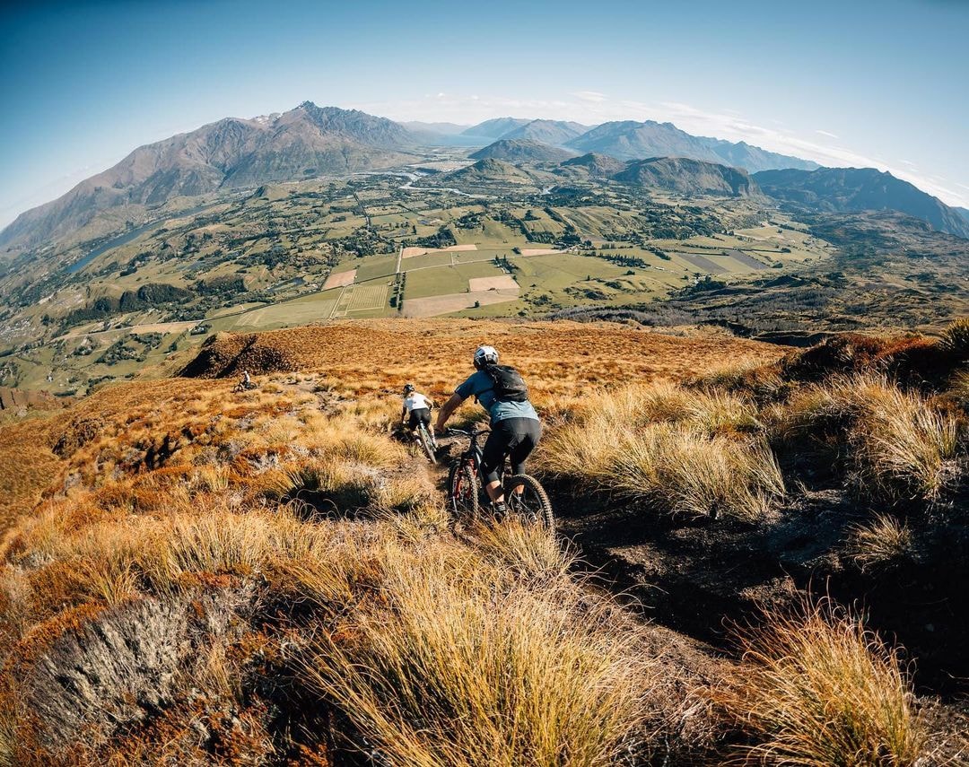 A group of mountain bikers descend the Coronet hill side in Queenstown, New Zealand.