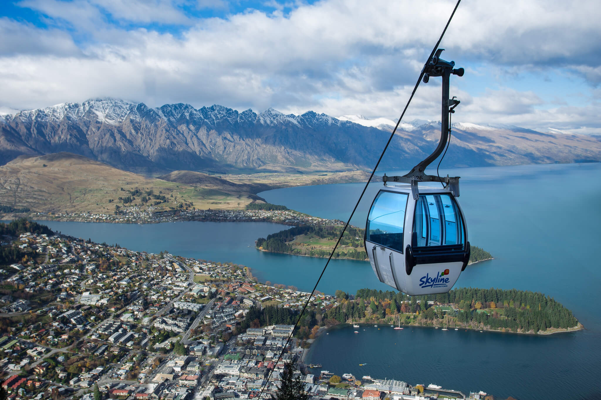 Gondola with Queenstown and the Remarkables in the background on a slightly cloudy day.