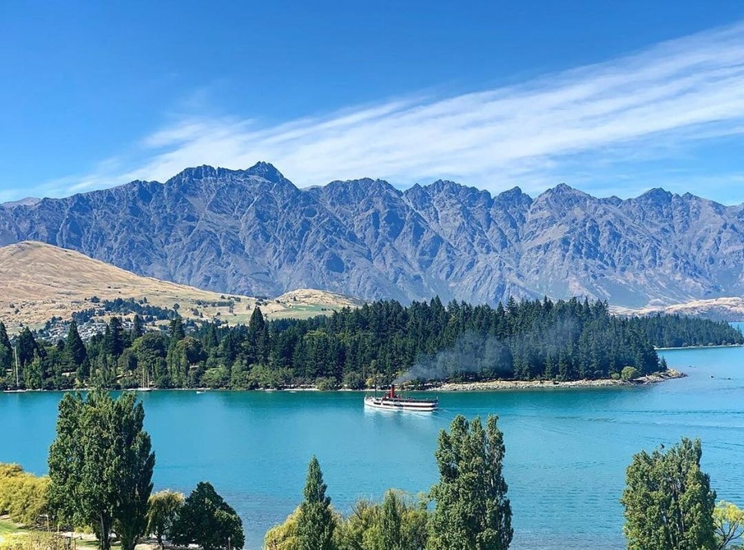 The Earnslaw steams into Queenstown Bay with The Remarkables Mountains in the background.