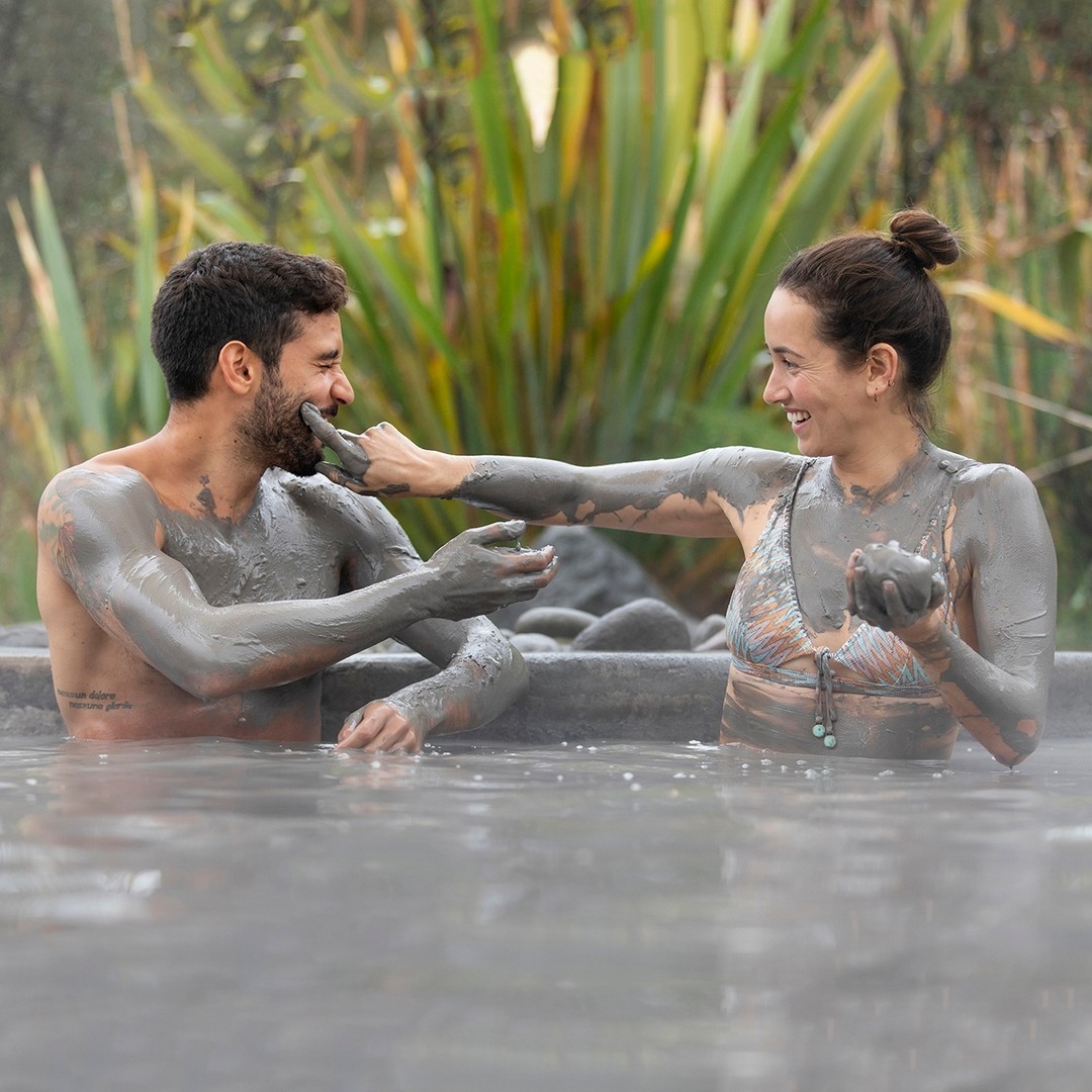 A couple enjoys a mud bath spa at Hell's Gate in Rotorua New Zealand.