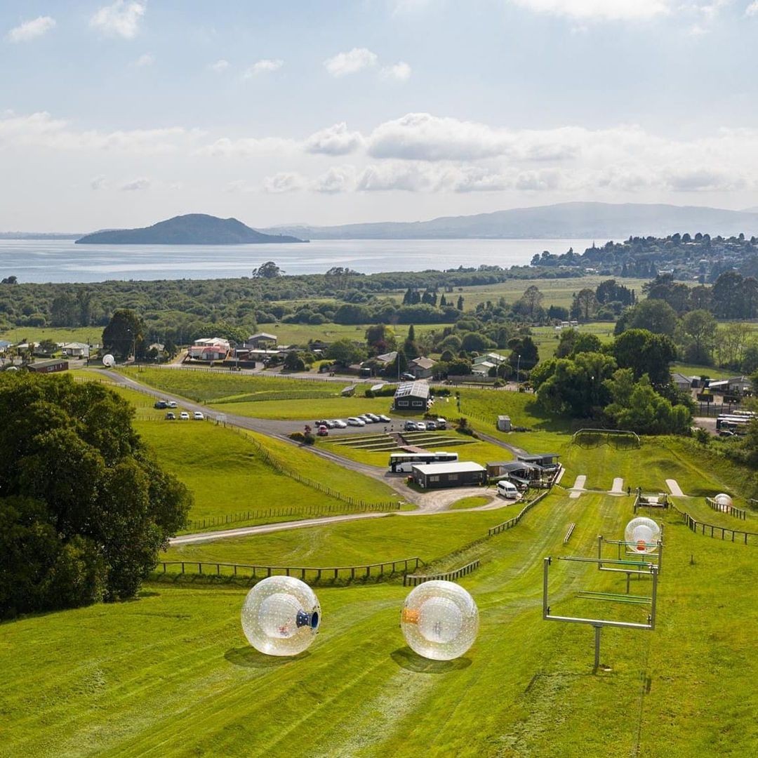 A group of people roll down the steep slopes of the Rotorua Zorb.