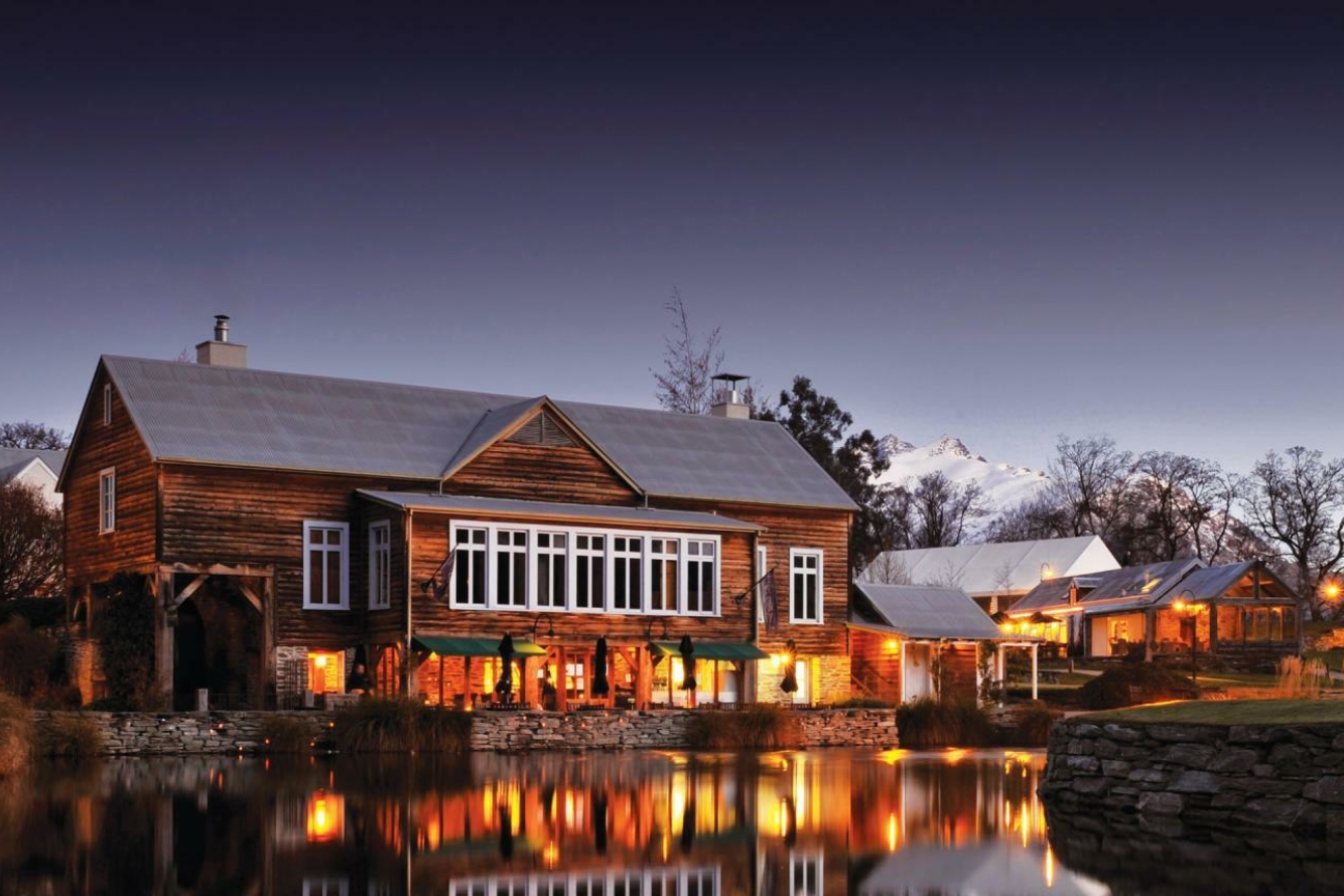 A historic building and mirrored lake in The Millbrook Resort, Queenstown.