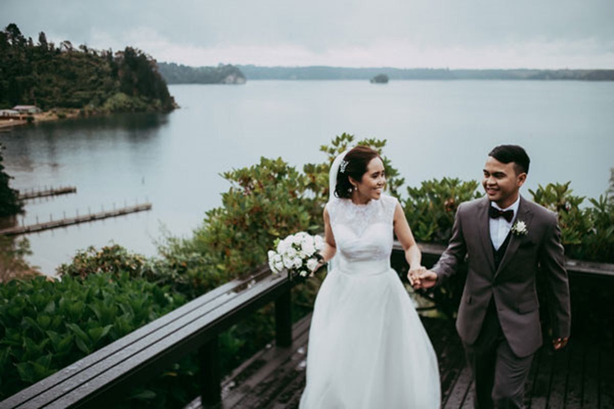 A couple hold hands and smile at each other following their wedding ceremony at the Moose Lodge Estate in Rotorua, New Zealand.