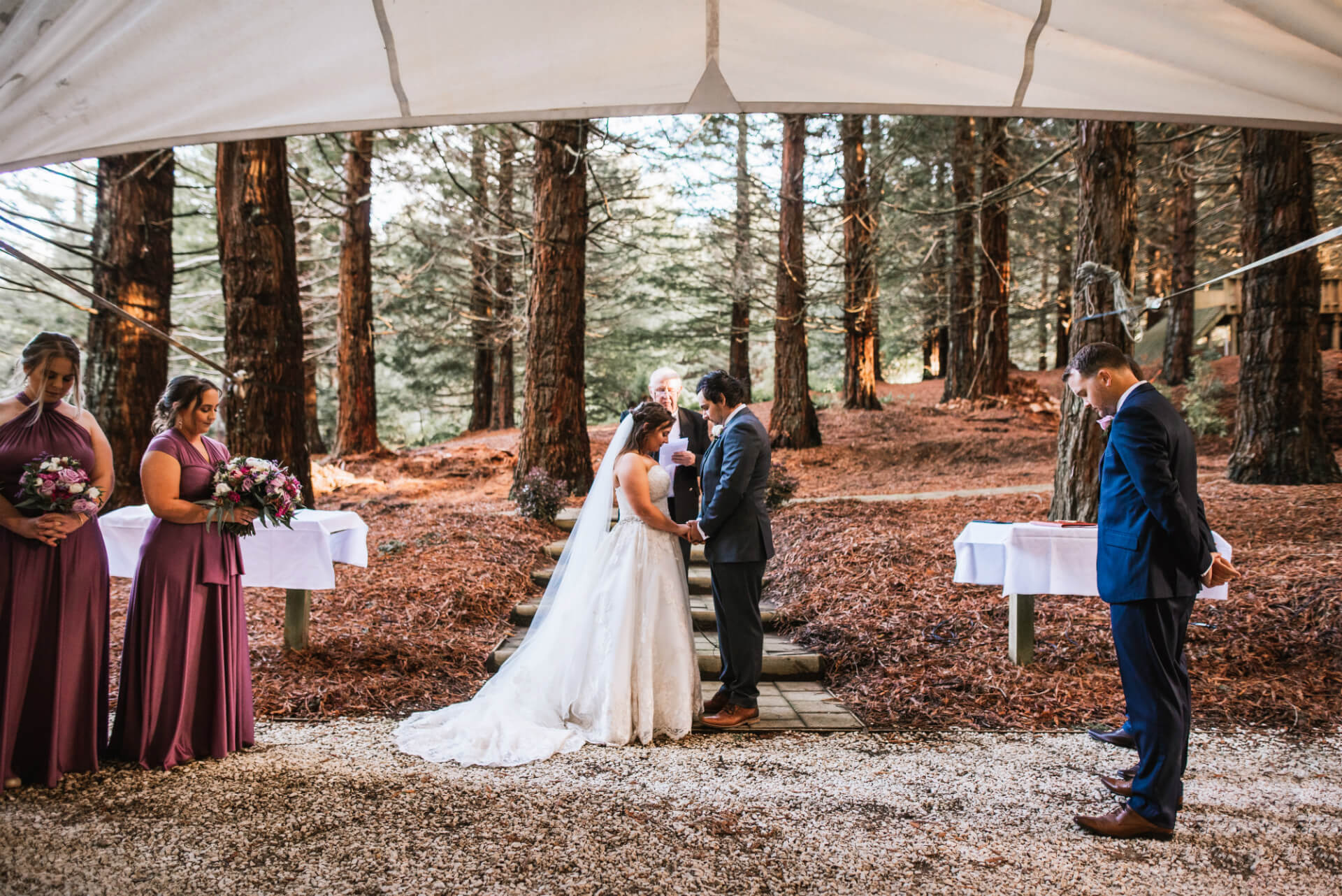 A Newly Married Couple Holds Hands At The Front Of Their Wedding Service.