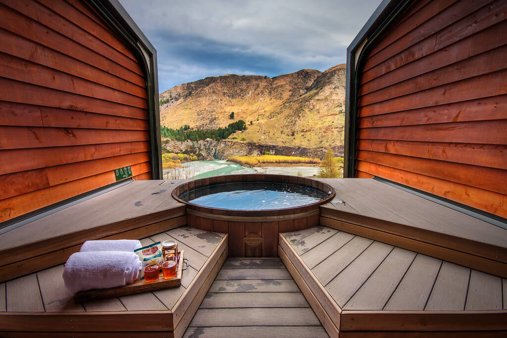 A private spa overlooking mountains and a river at Onsen Hot Pools.
