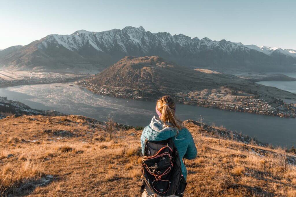 A woman overlooks Lake Wakatipu and the Remarkables from a vantage point up Queenstown Hill.