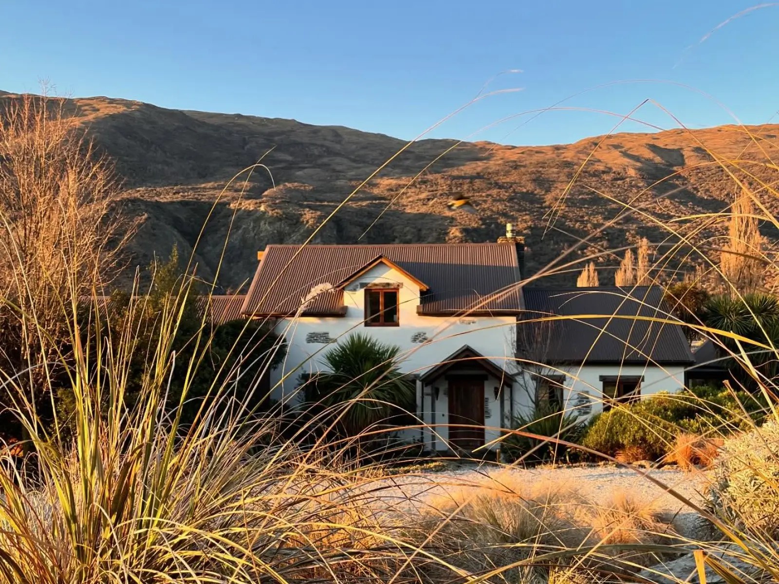 A large house in front of a hill in the Queenstown area.