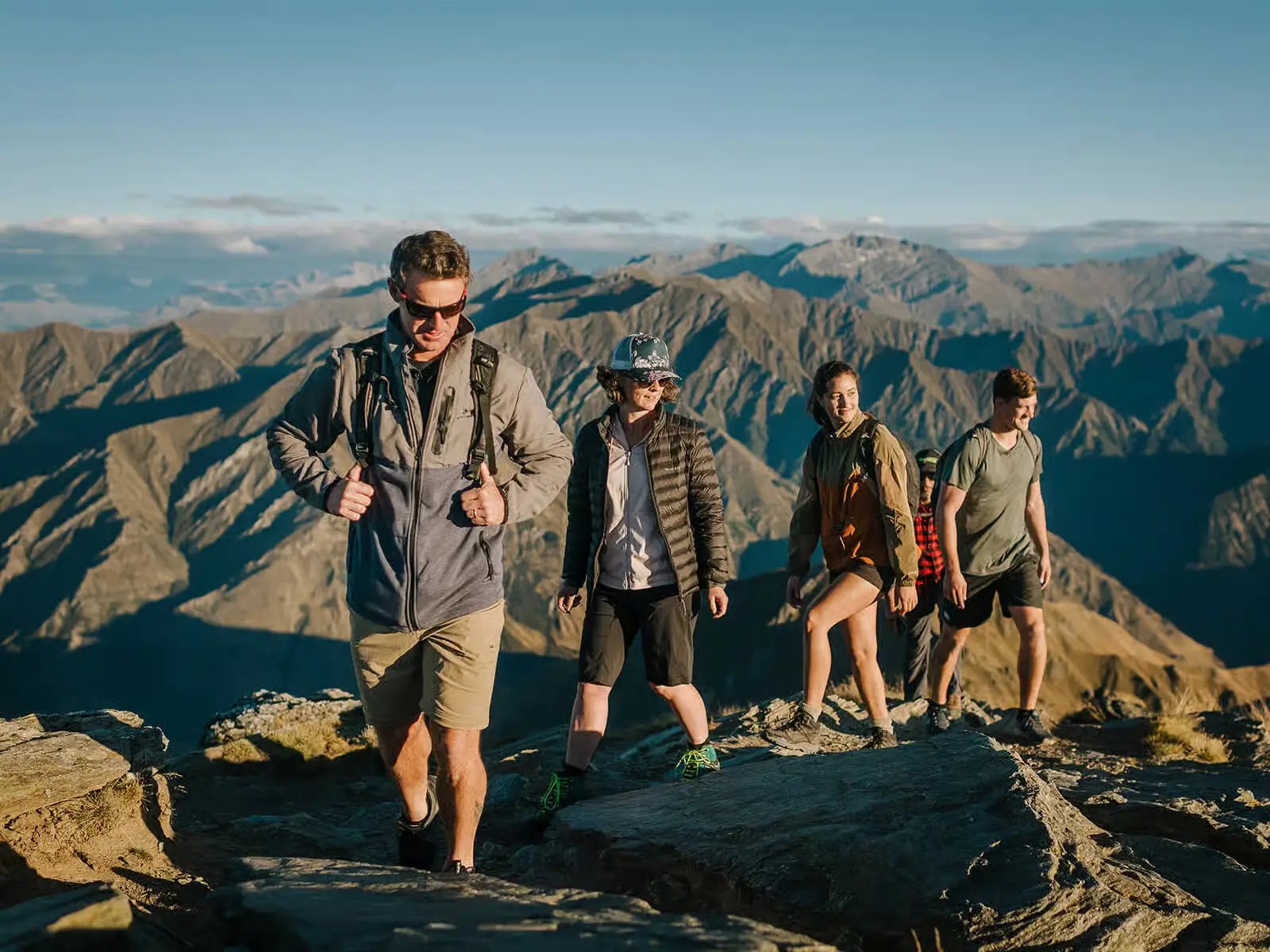 Five people hiking the Ben Lomond mountain on a sunny day.