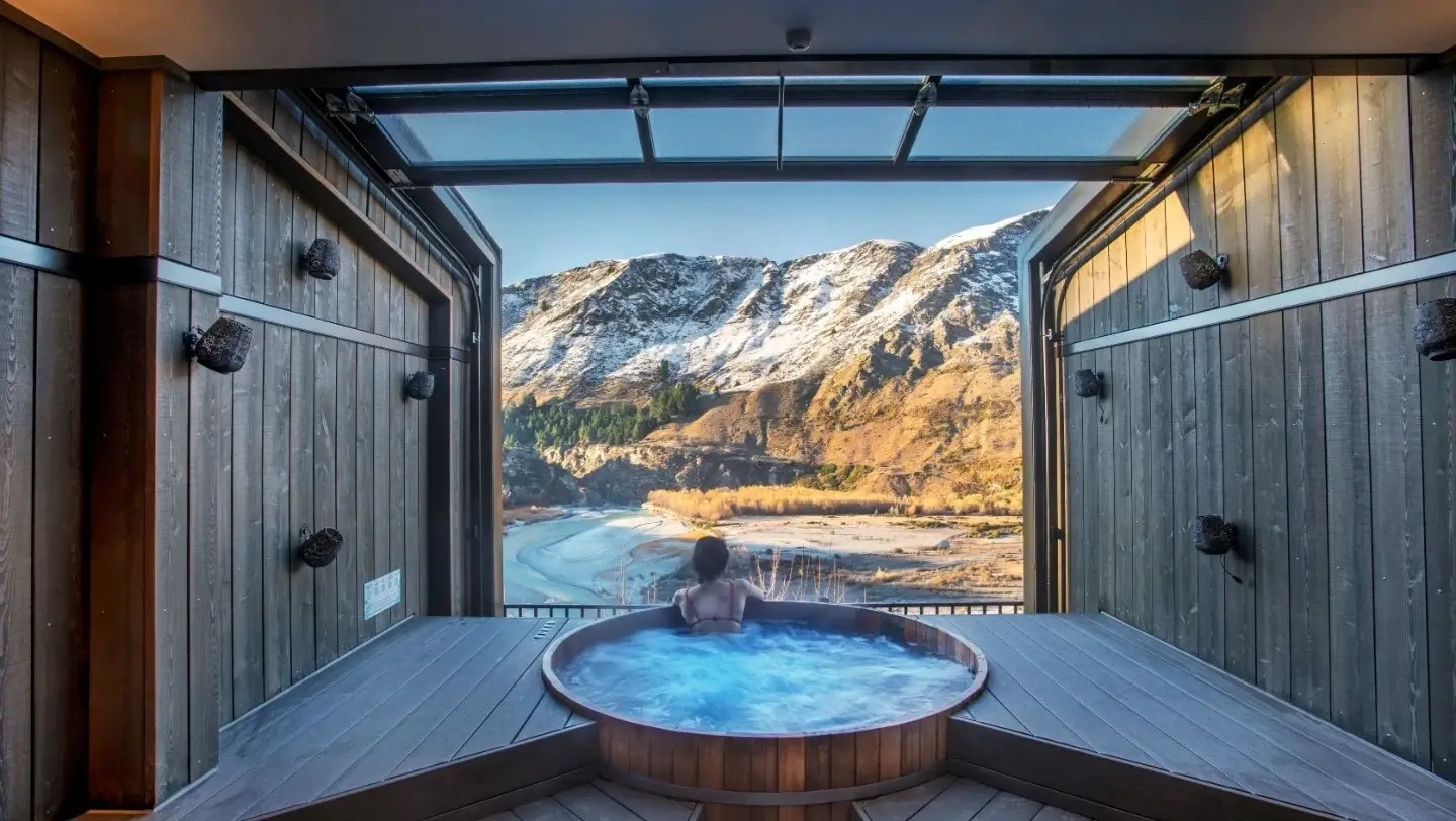 Woman relaxing at Onsen and looking out at beautiful view.
