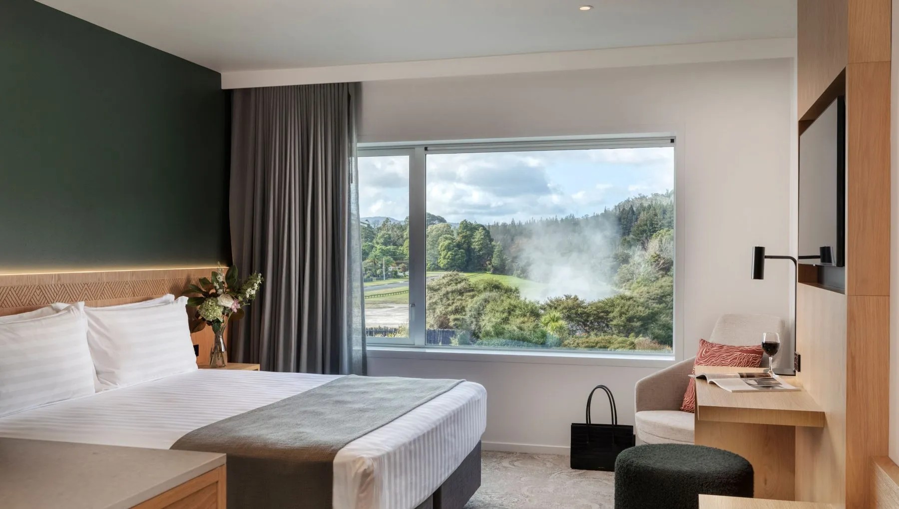 Modern hotel room with scenic bush views, stylish decor, comfortable amenities and large picture windows.