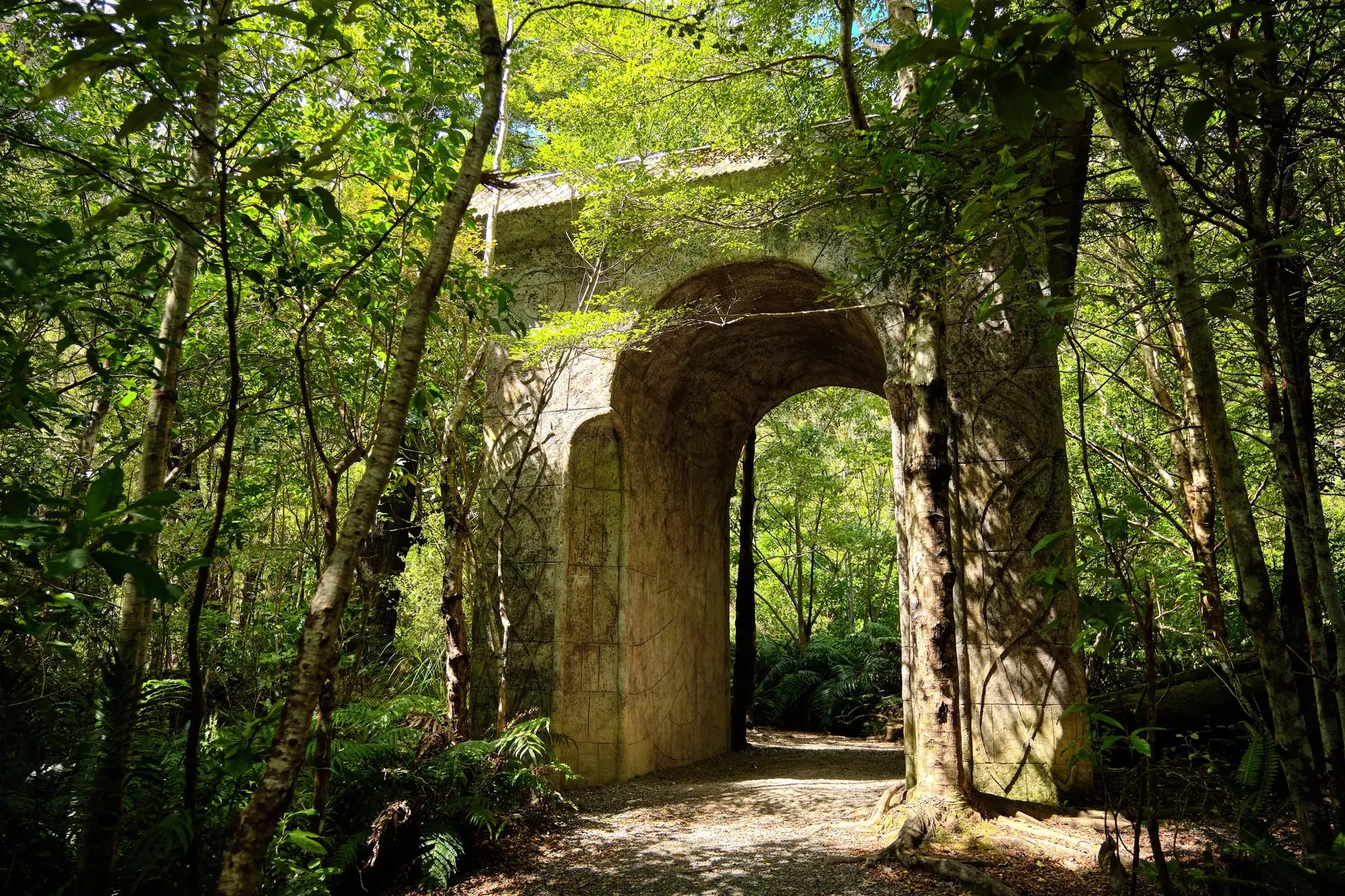 Large stone archway inside Kaitoke Regional Park surrounded by lush greenery.