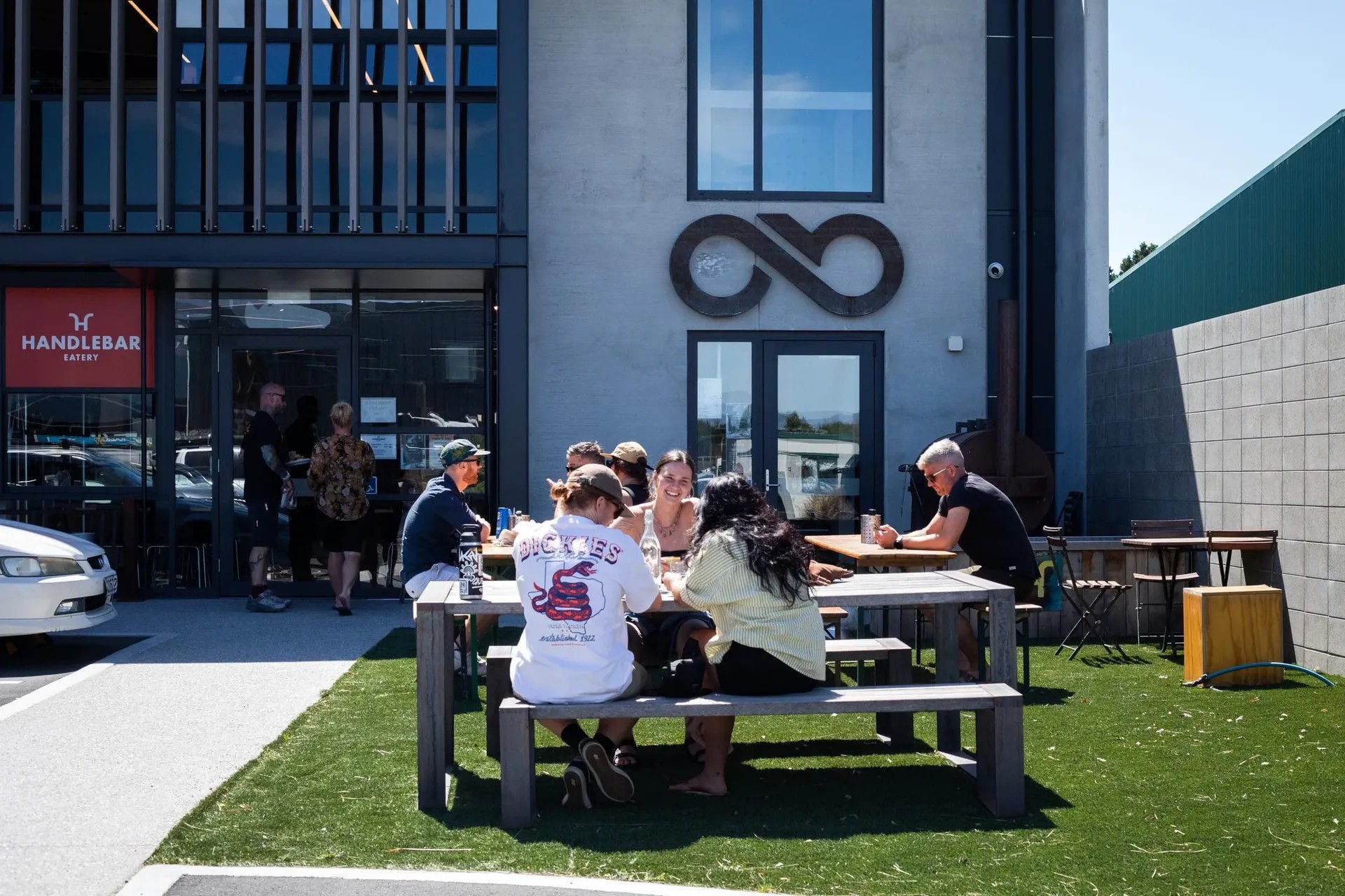Customers sitting outside, smiling and enjoying beer, company and sunshine.