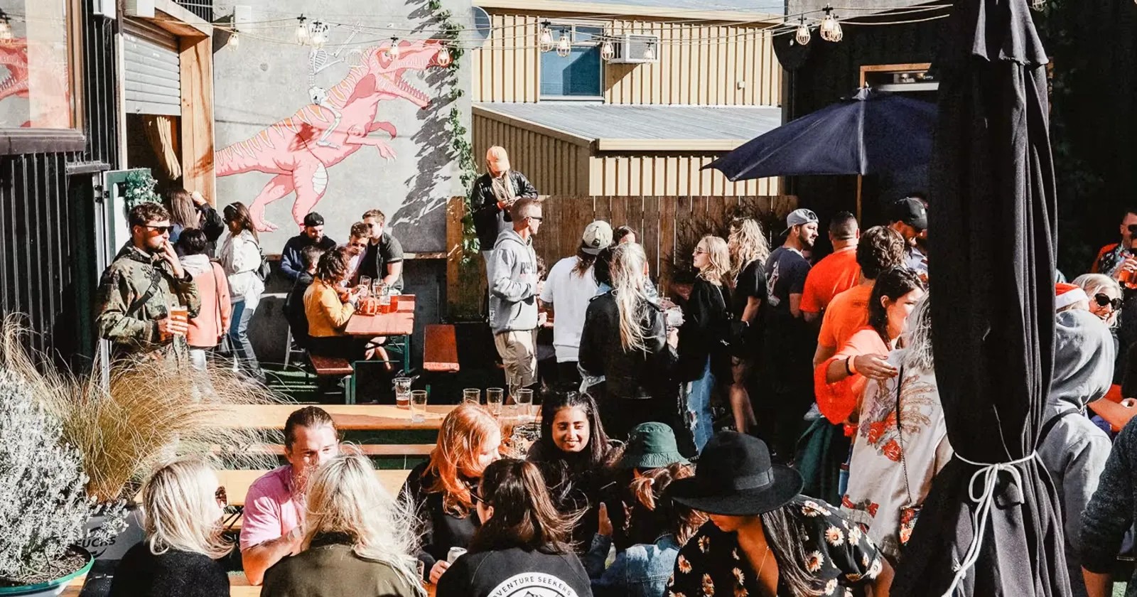 Many customers drinking beer in the outdoor sit-down area at Searchlight Brewery in Queenstown.