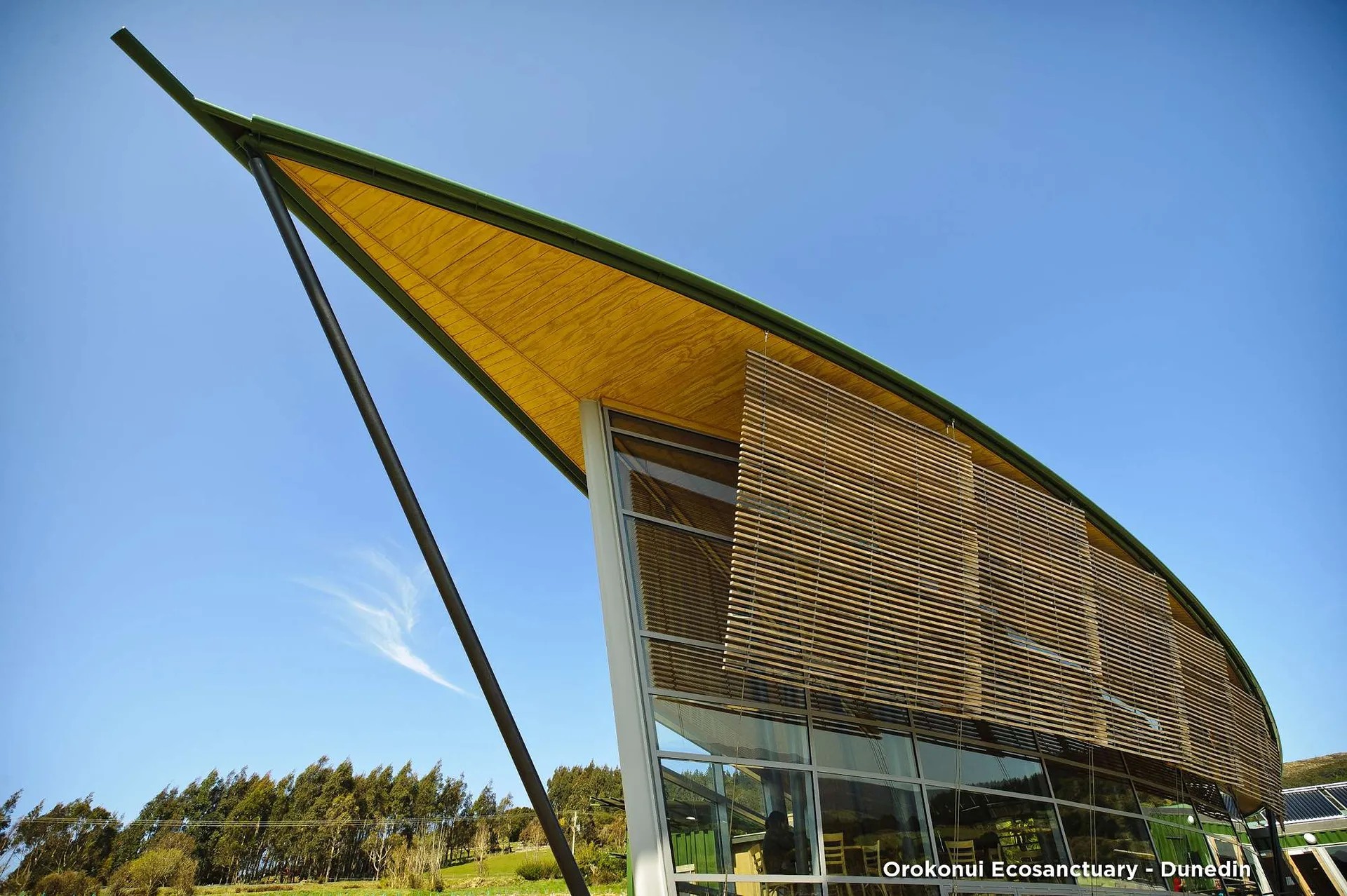 Orokonui Ecosanctuary visitor centre with curved roof and glass walls in Dunedin.