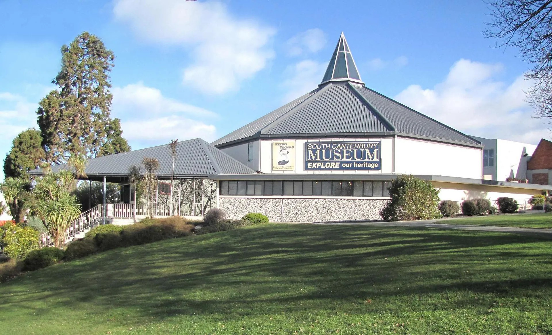 South Canterbury Museum building with green lawn and trees.