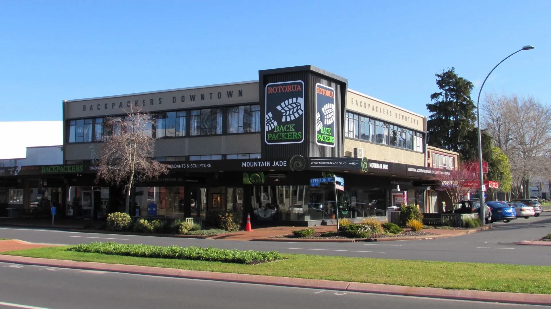 Exterior of a two-storey building in Rotorua city centre with colourful signage for Rotorua Backpackers.