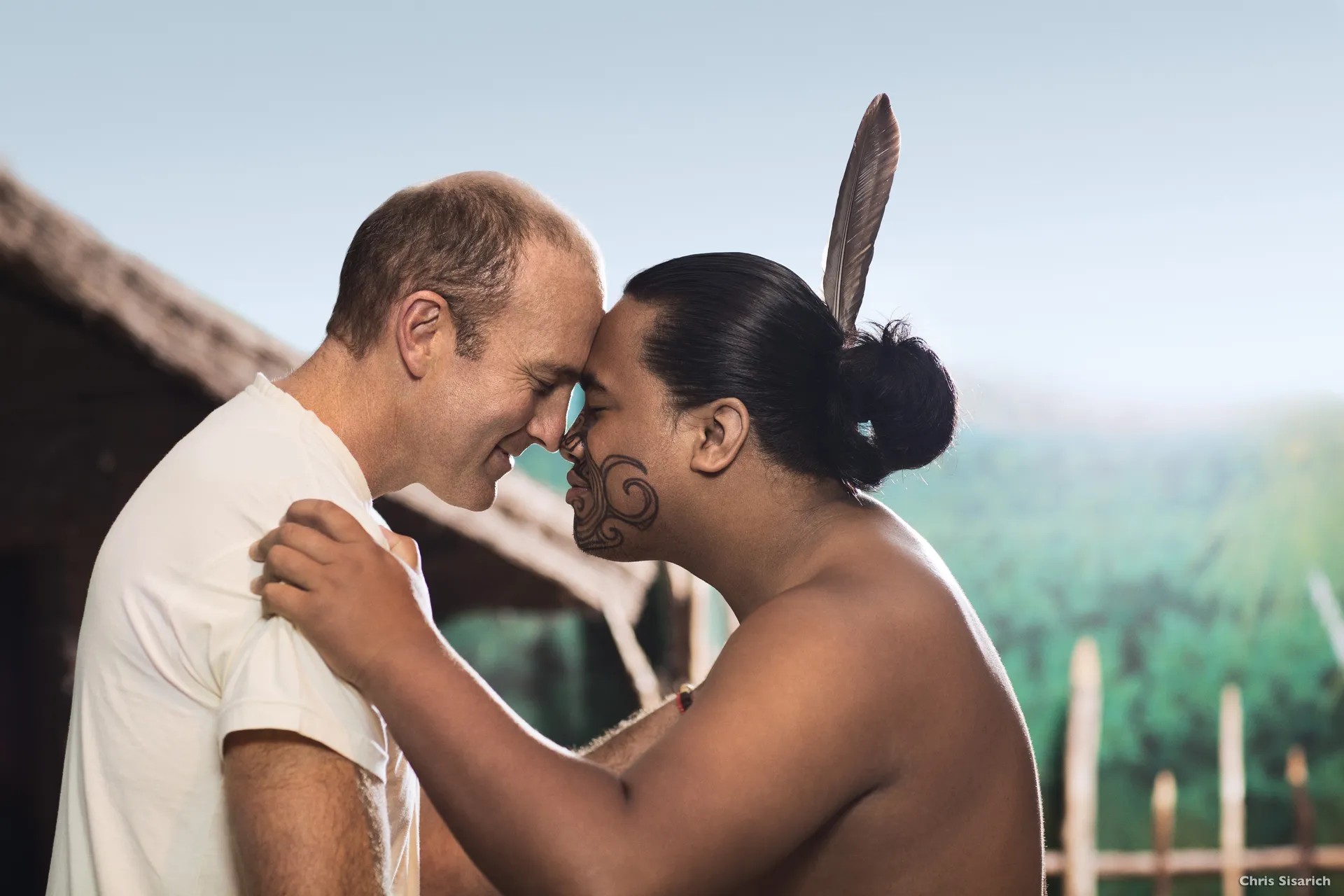 European and Maori man pressing noses and foreheads against each other in a hongi.