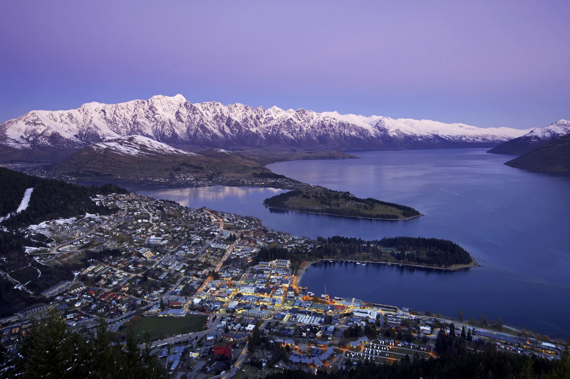 An aerial shot of Queenstown with the city centre, mountains and lake.