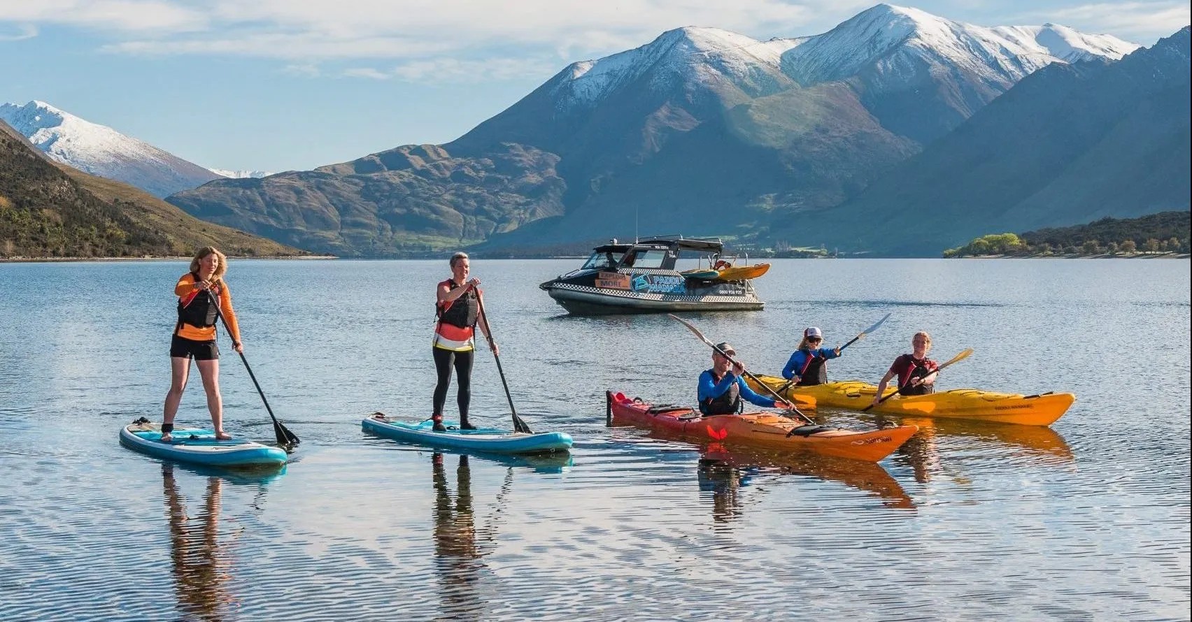 Group of paddleboarders and kayakers on Lake Wānaka.