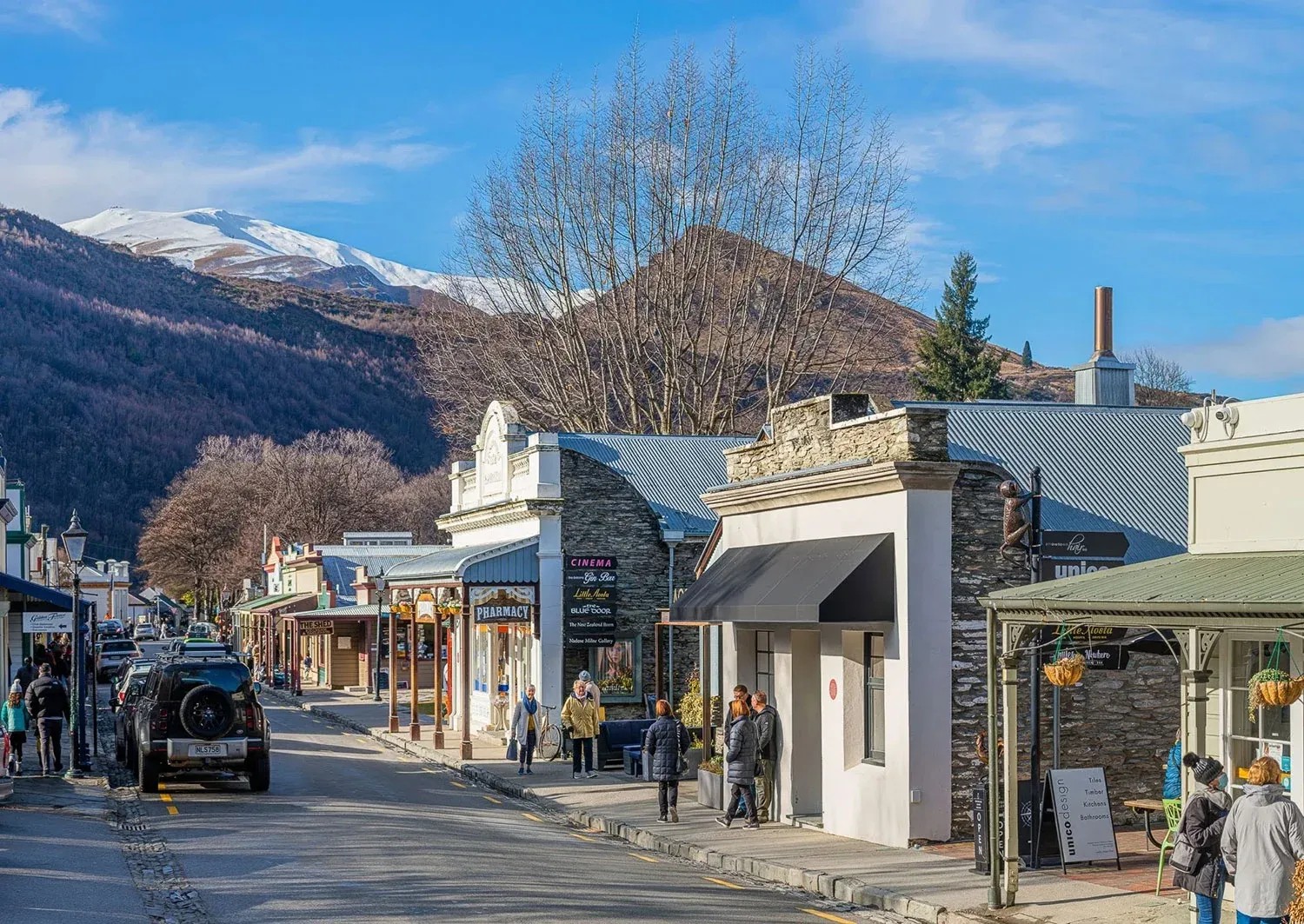 People walking through Arrowtown town centre on a sunny day