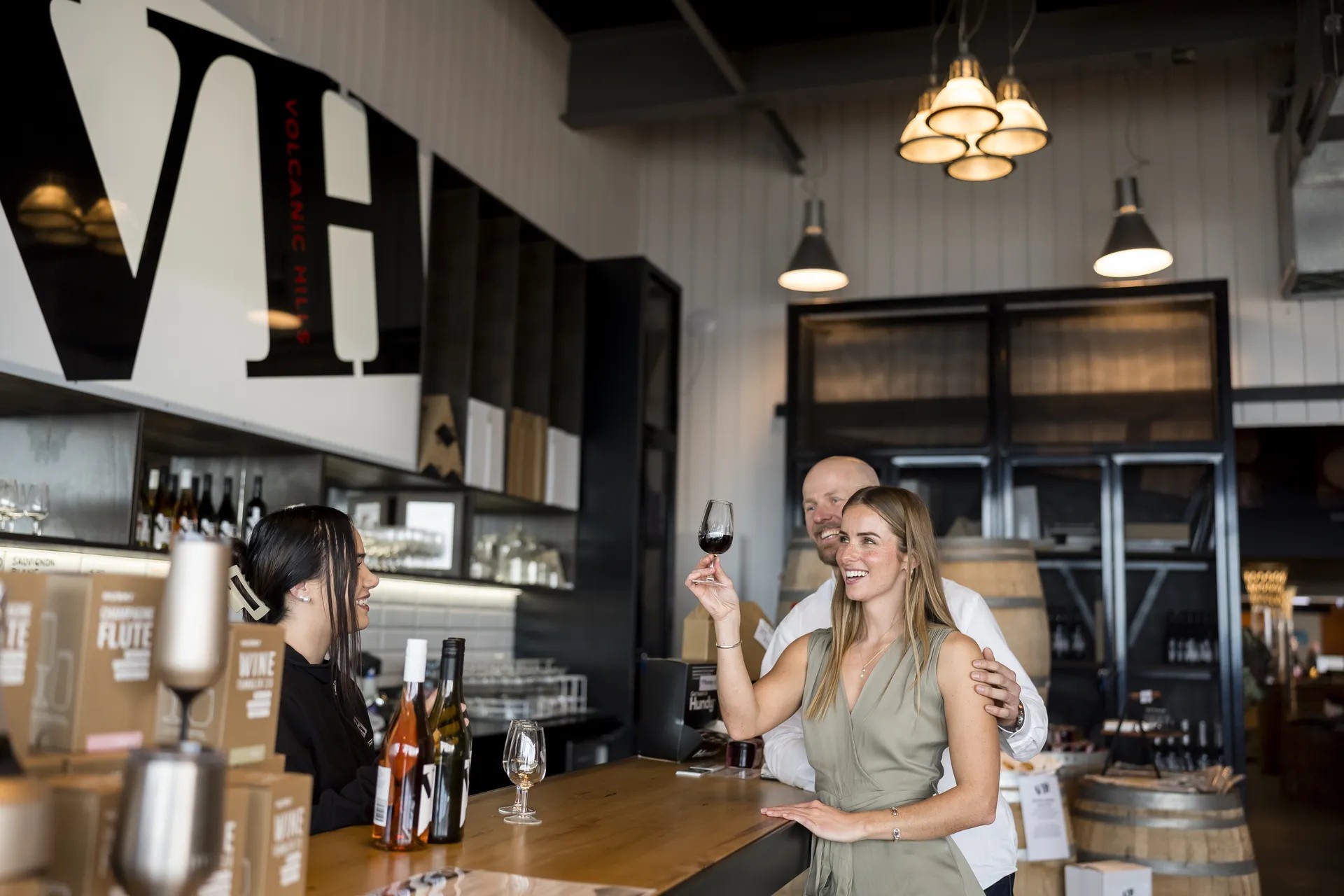 Couple trying a glass of red wine together in a rustic bar.